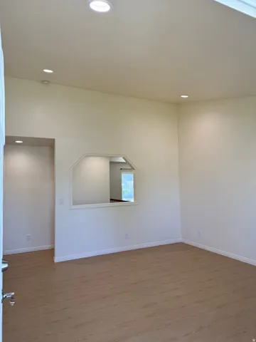 Spacious interior featuring wood-finish flooring, recessed lighting, and a vaulted ceiling