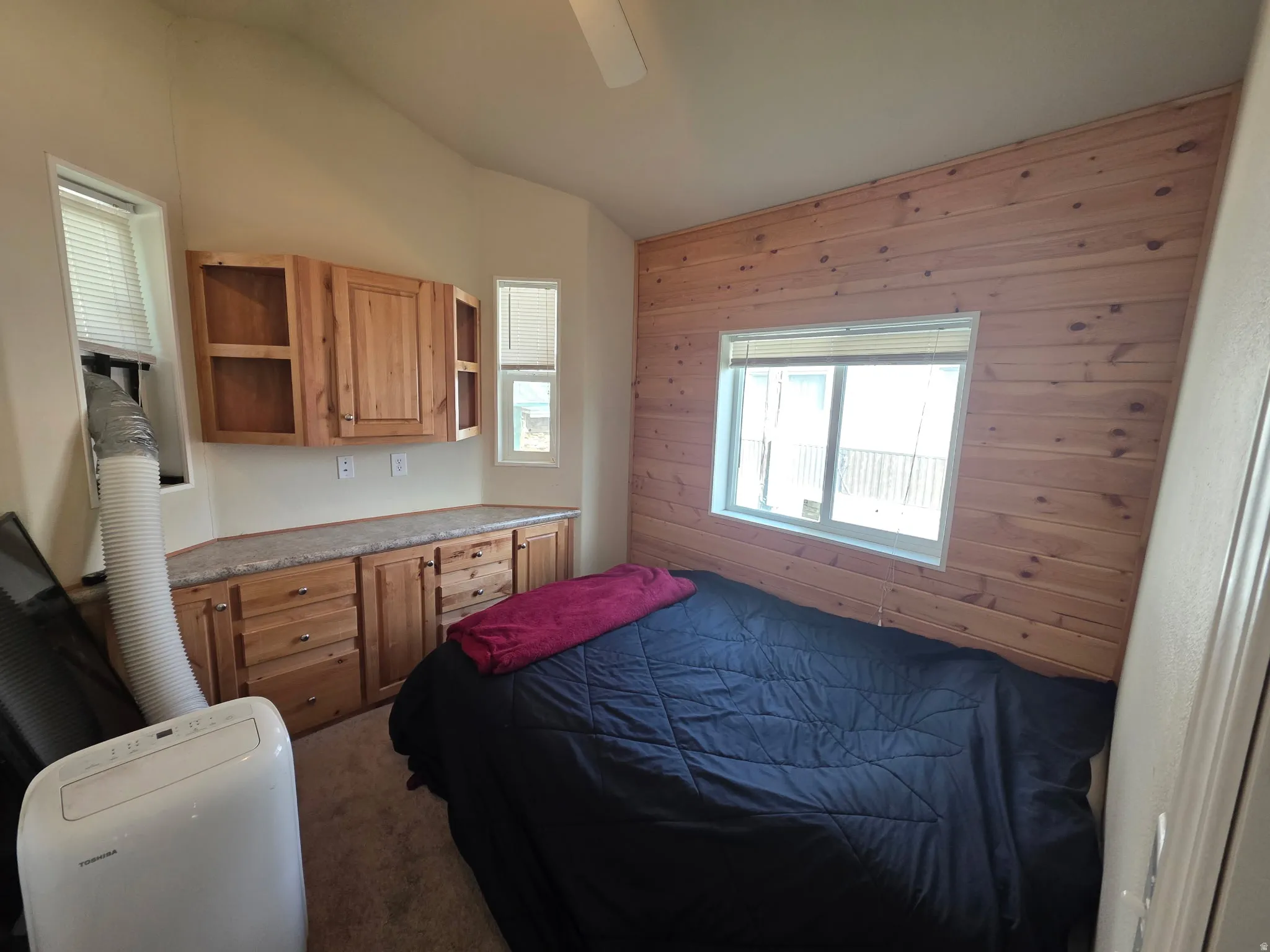 Bedroom featuring vaulted ceiling, ceiling fan, and carpet