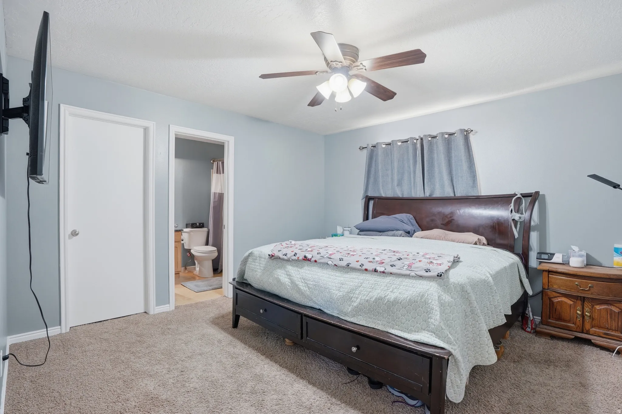 Bedroom with carpet flooring, ensuite bath, and ceiling fan