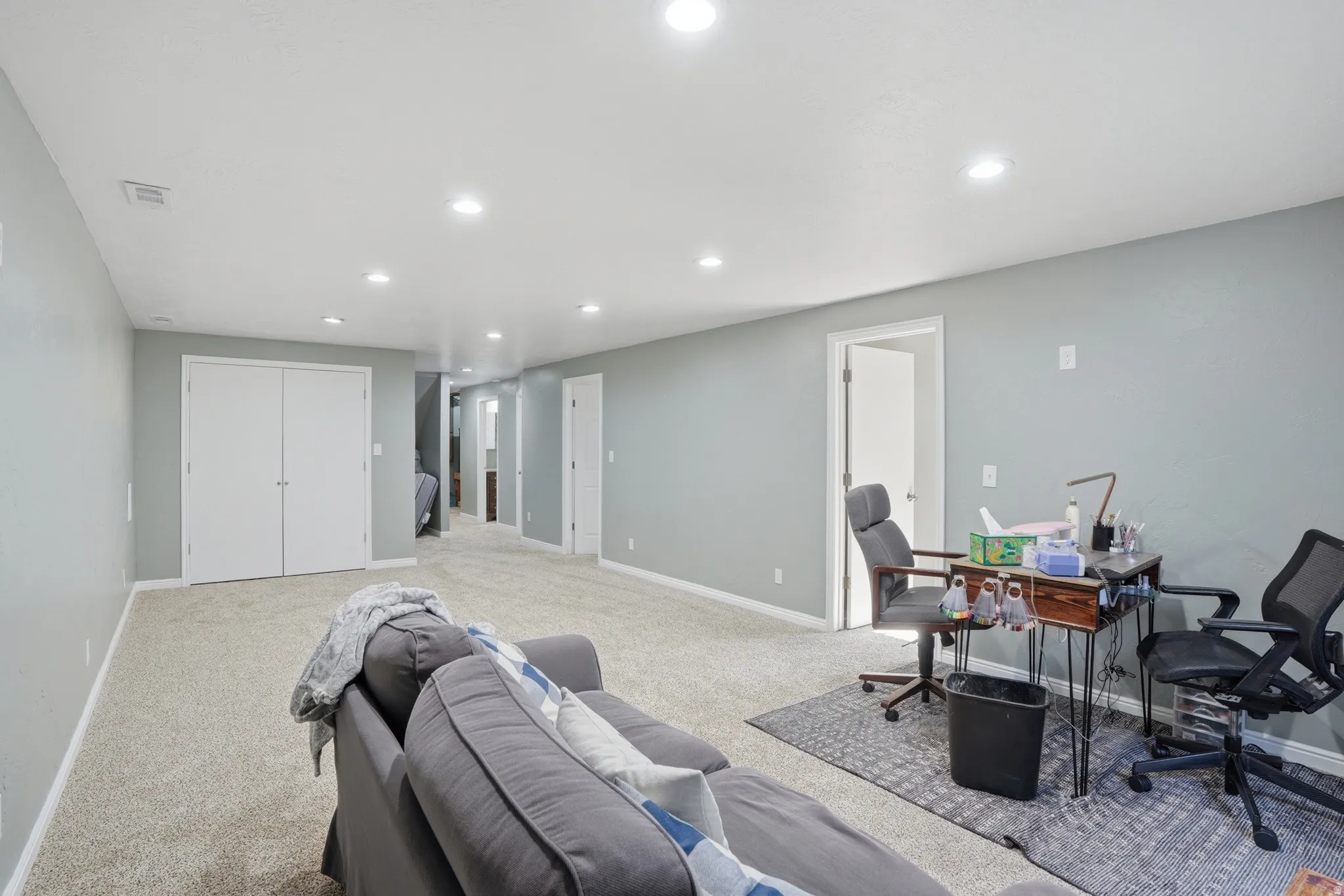 Home office with recessed lighting and light colored carpet