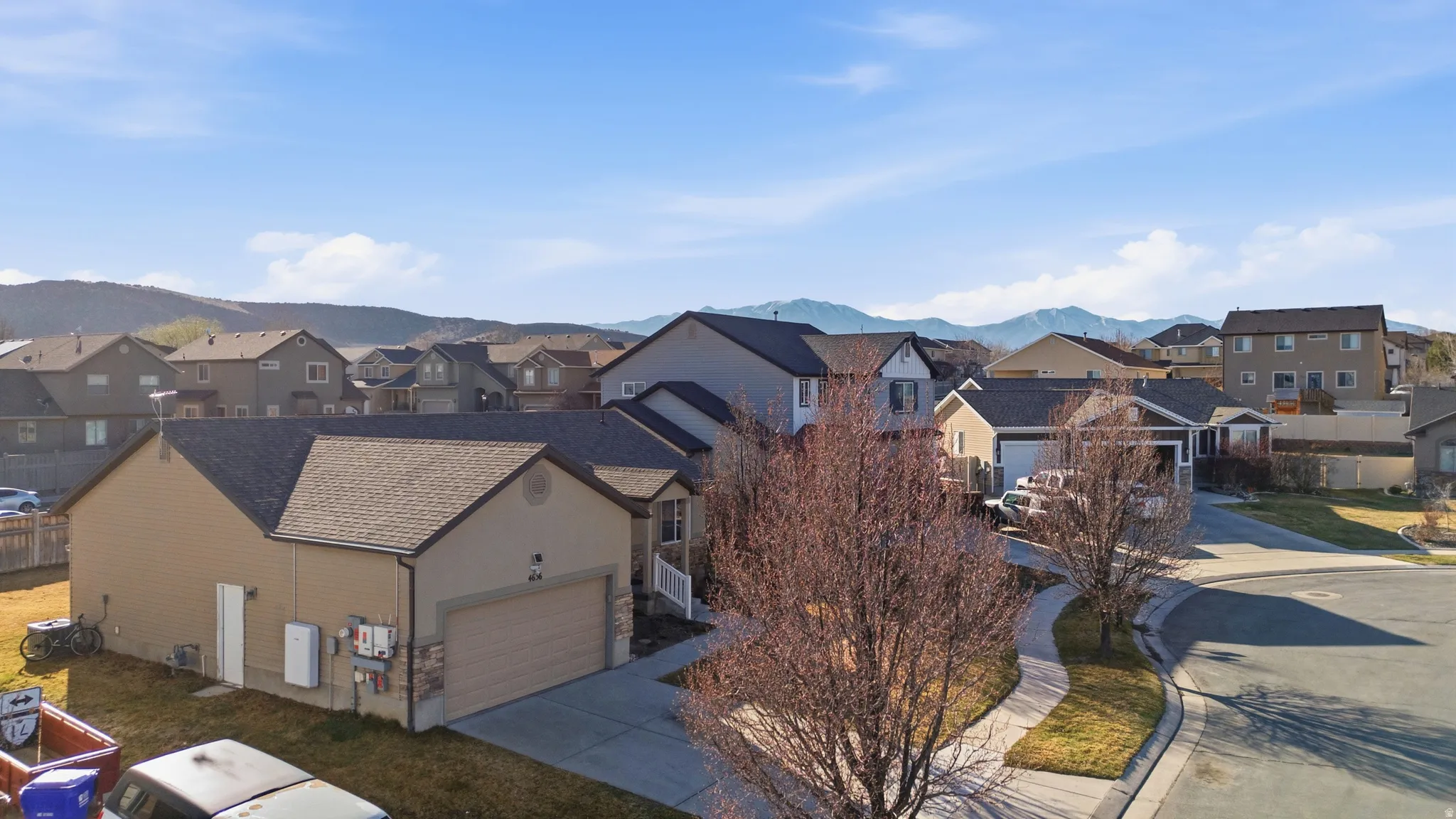 View of front of house with a residential view, concrete driveway, a garage, a mountain view, and stucco siding