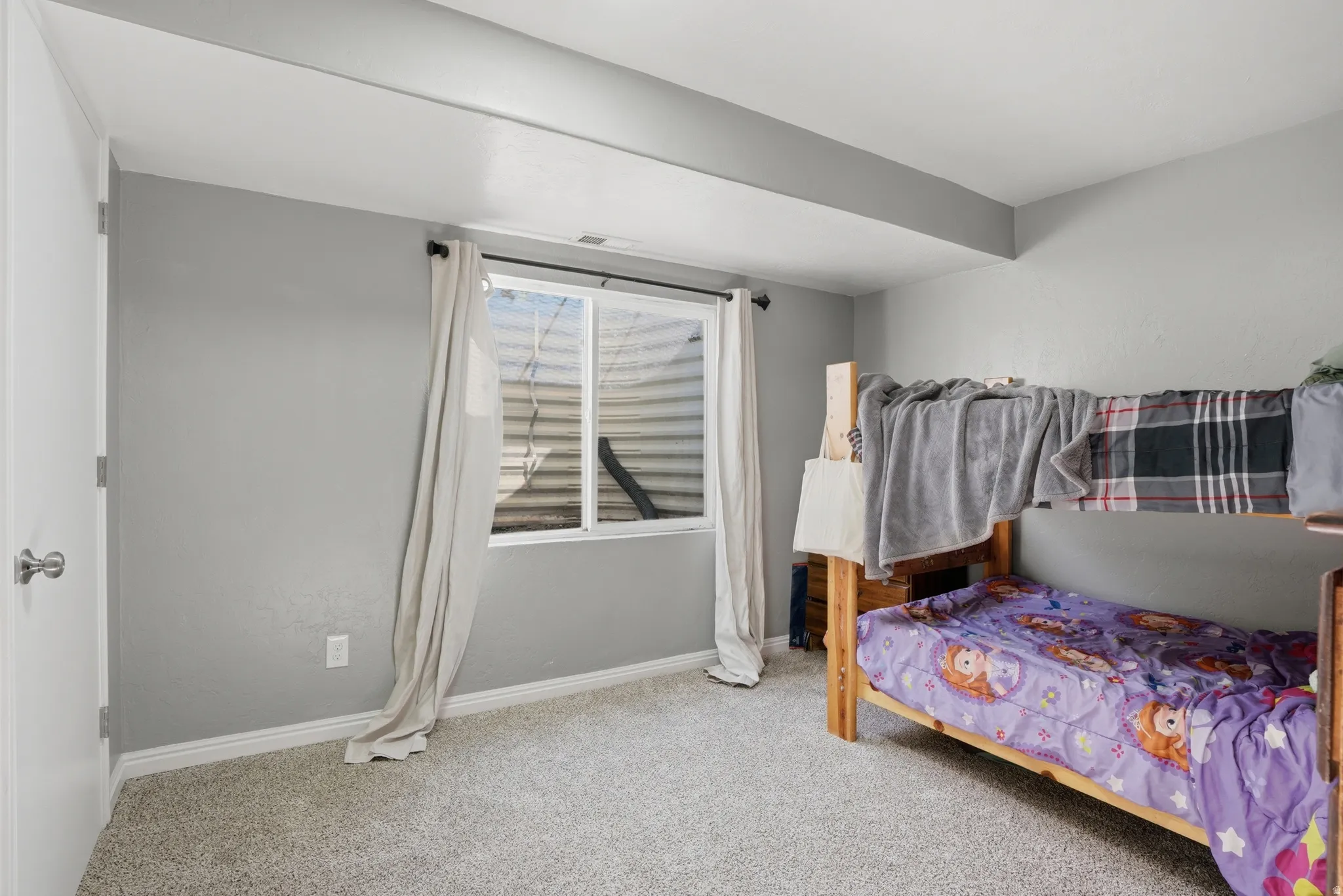 Bedroom with light carpet and baseboards