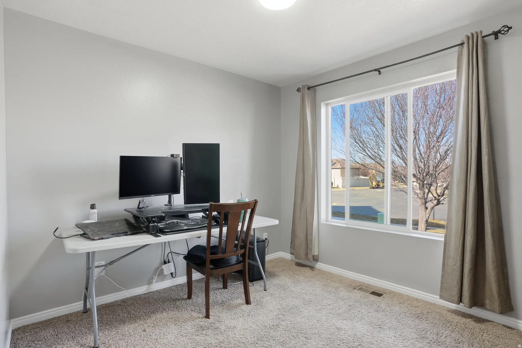 Home office featuring light carpet and baseboards. Could be a bedroom