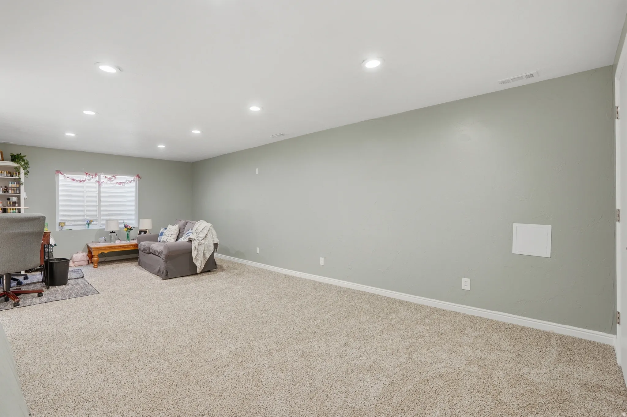 Living area featuring light colored carpet and recessed lighting