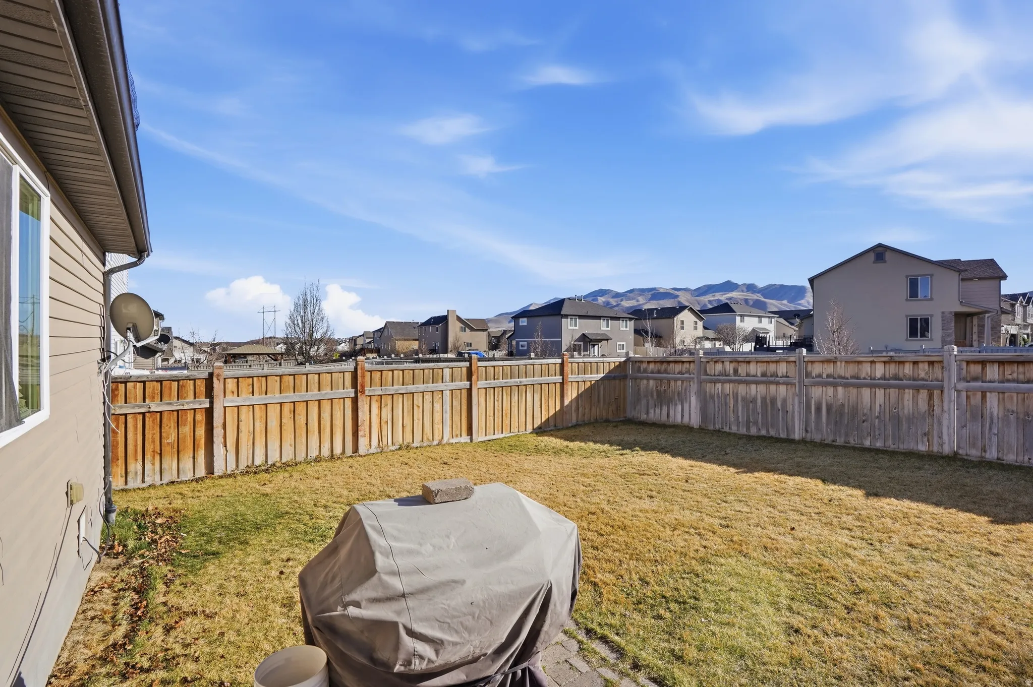 Fenced backyard featuring a residential view