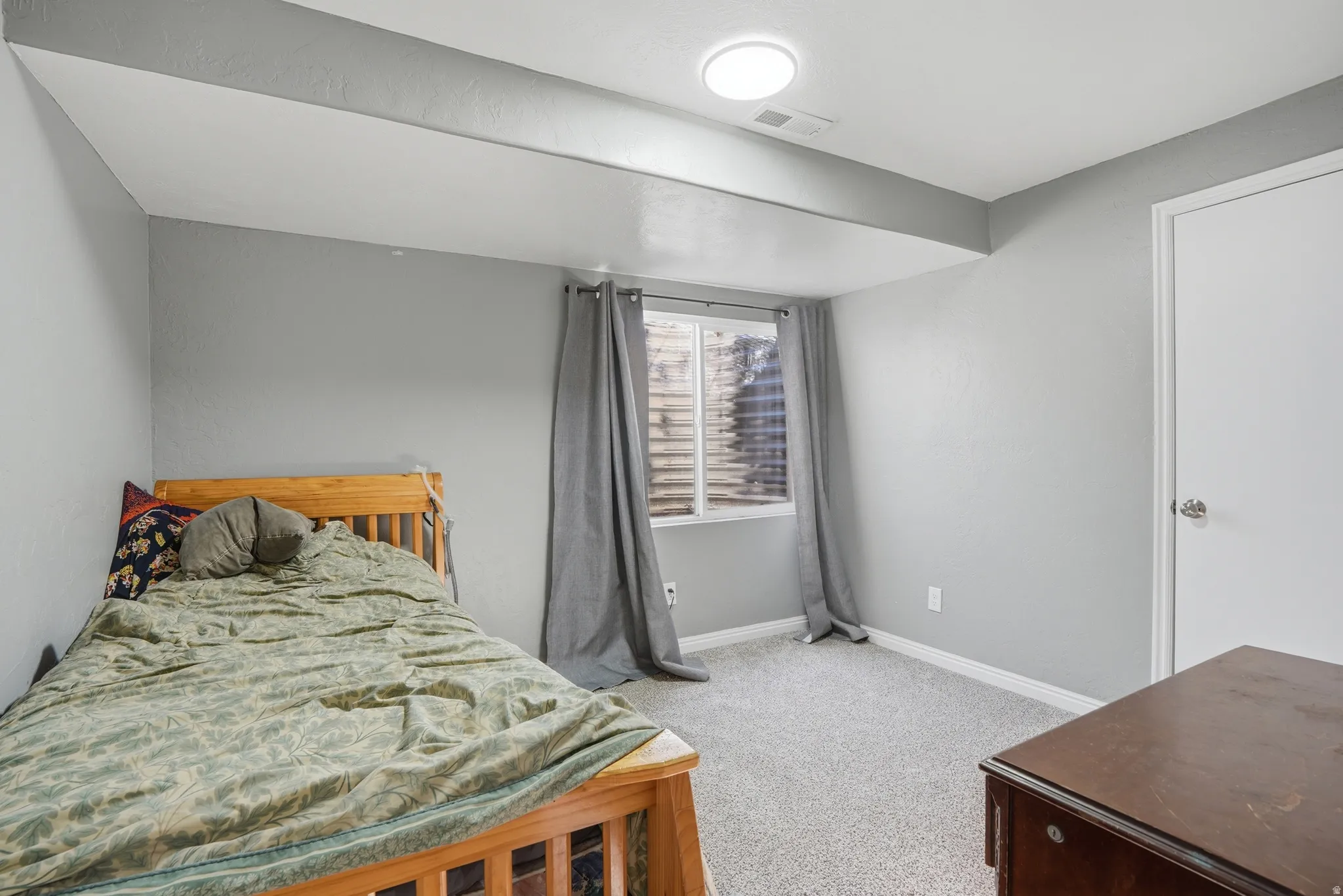 Bedroom with light carpet and baseboards