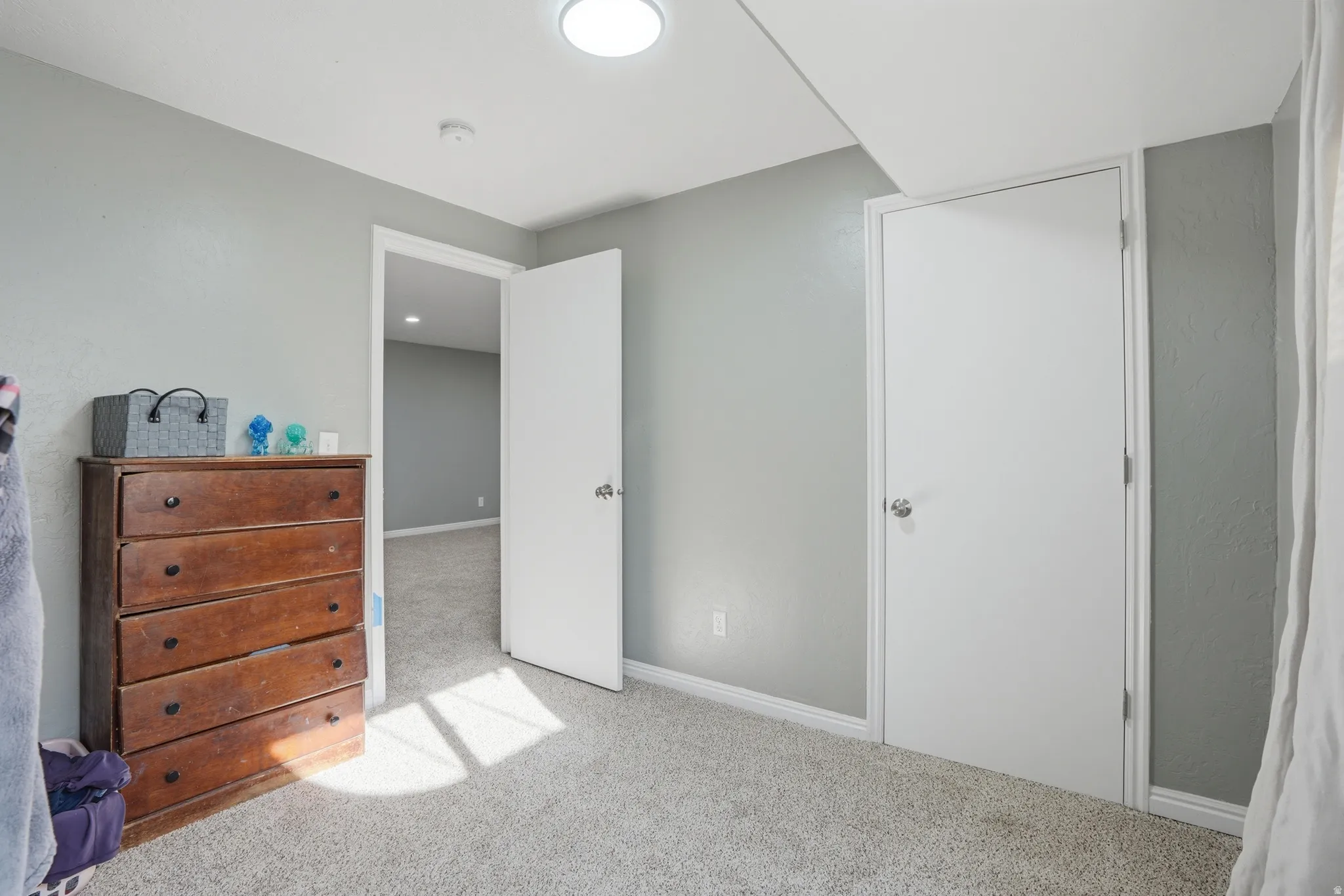 Bedroom with light carpet and baseboards