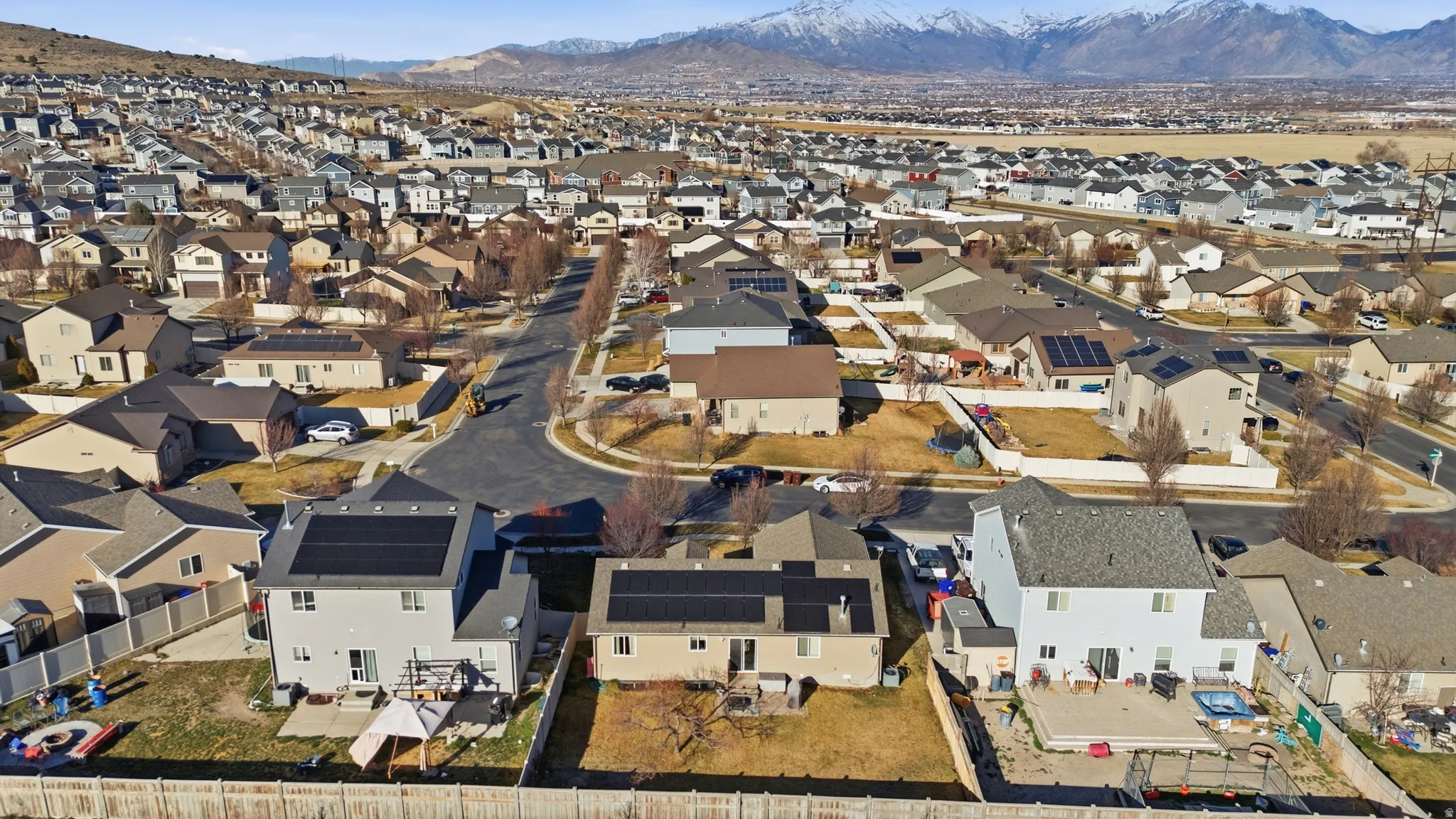 Aerial view of property and surrounding area with a mountainous background and nearby suburban area
