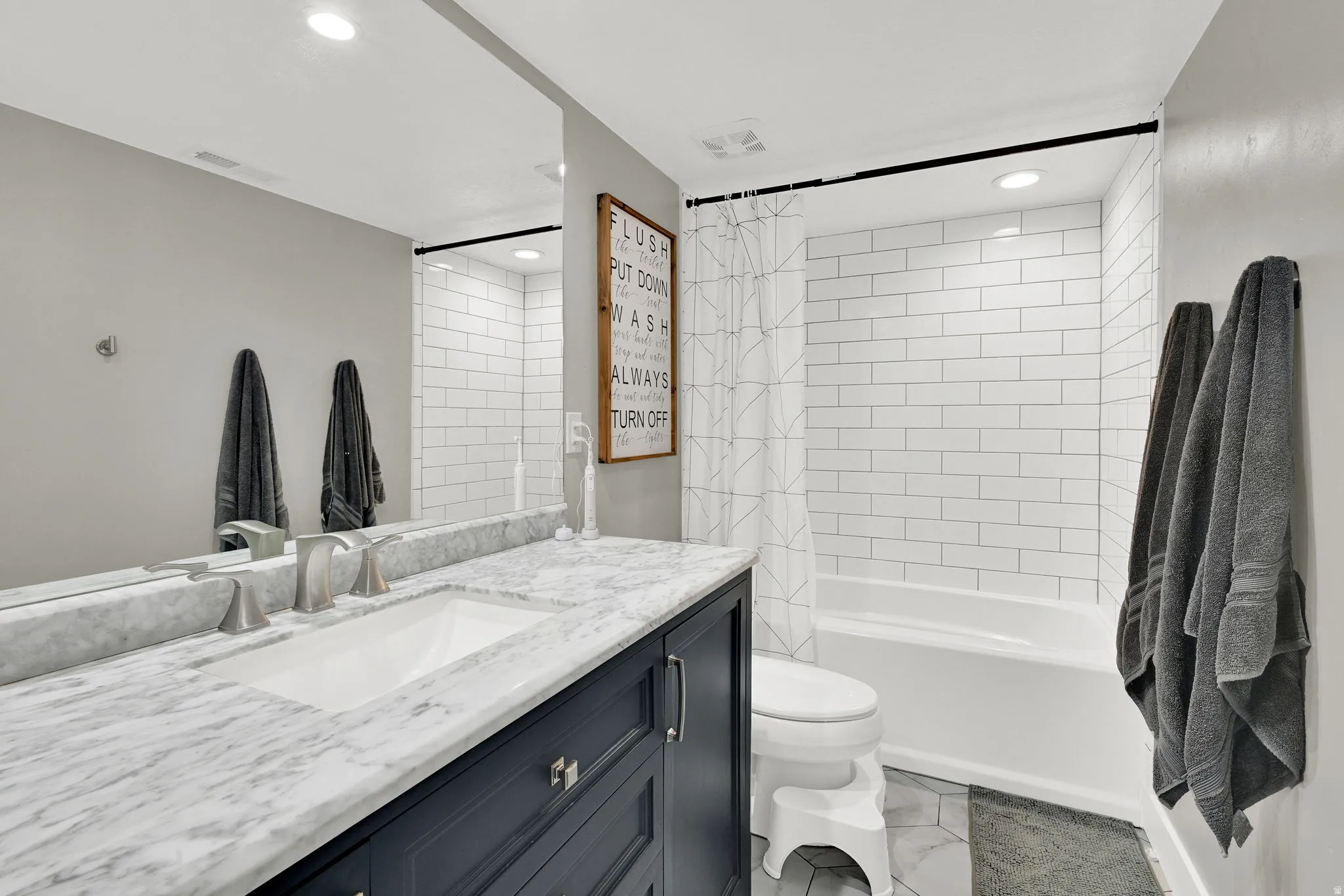 Bathroom with vanity, shower / tub combo with curtain, and recessed lighting