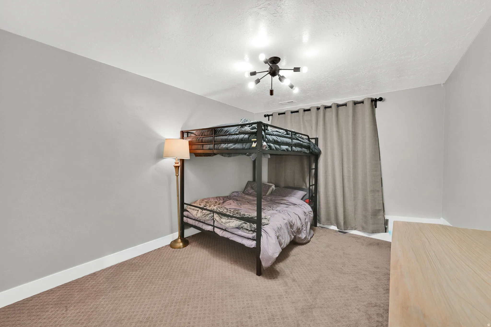 Bedroom with light carpet and a textured ceiling