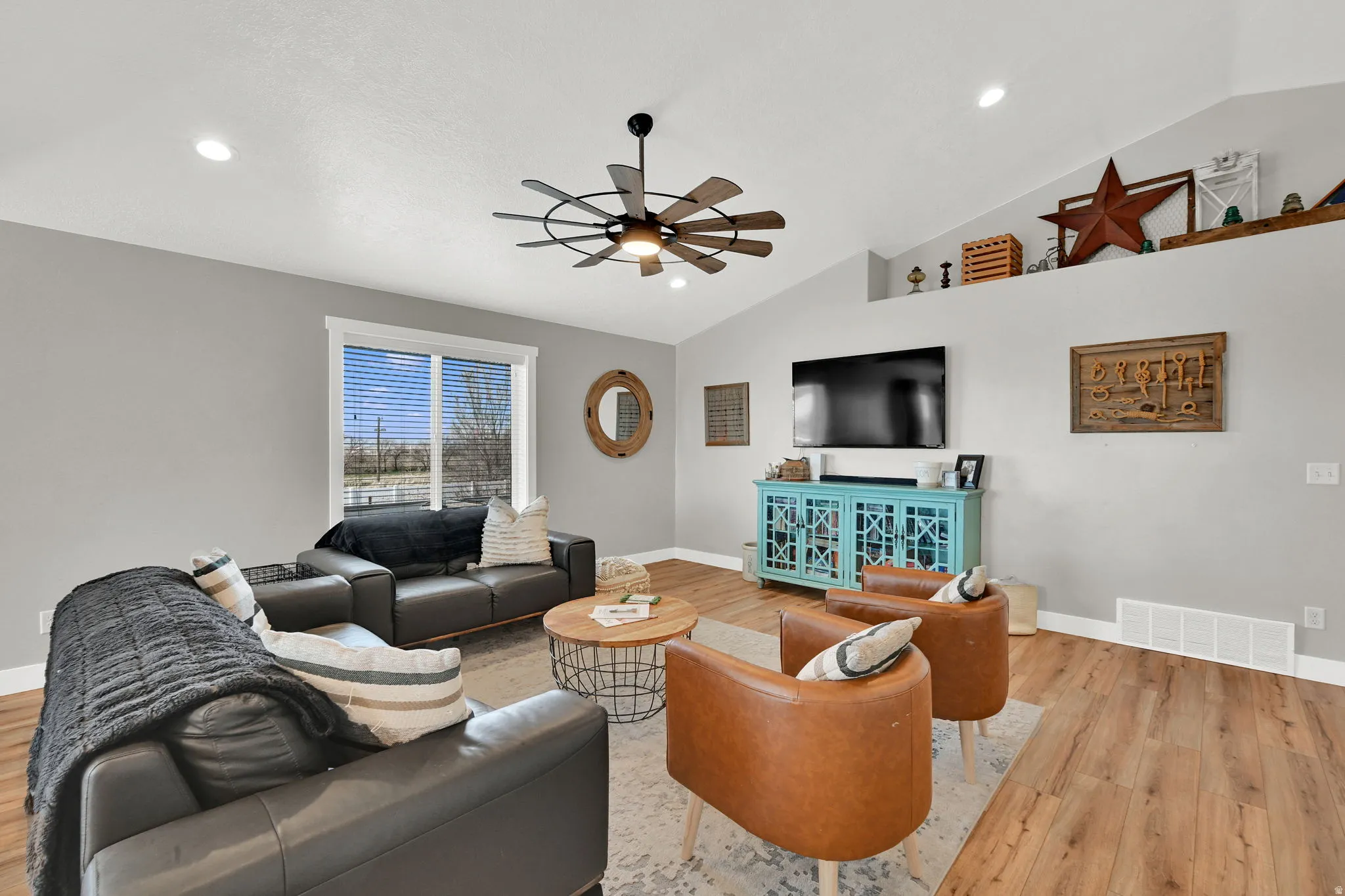 Living area featuring wood finished floors, ceiling fan, vaulted ceiling, and recessed lighting