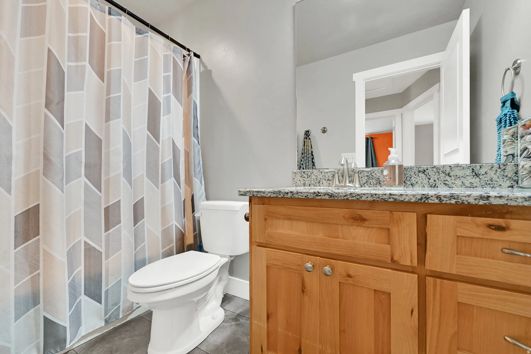 Full bathroom with vanity, a shower with shower curtain, and dark tile patterned flooring