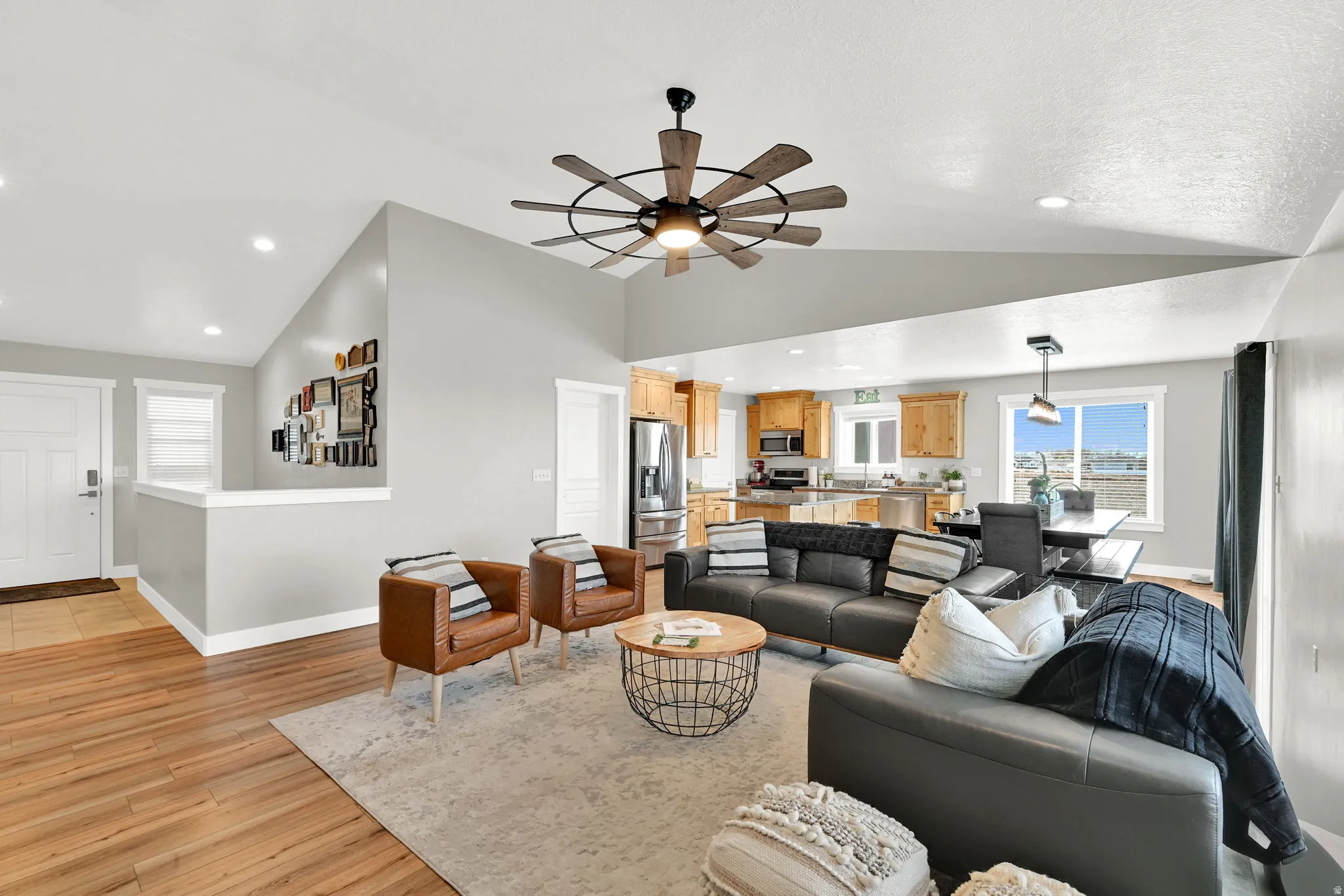 Living area featuring light wood-style floors, a ceiling fan, recessed lighting, and lofted ceiling