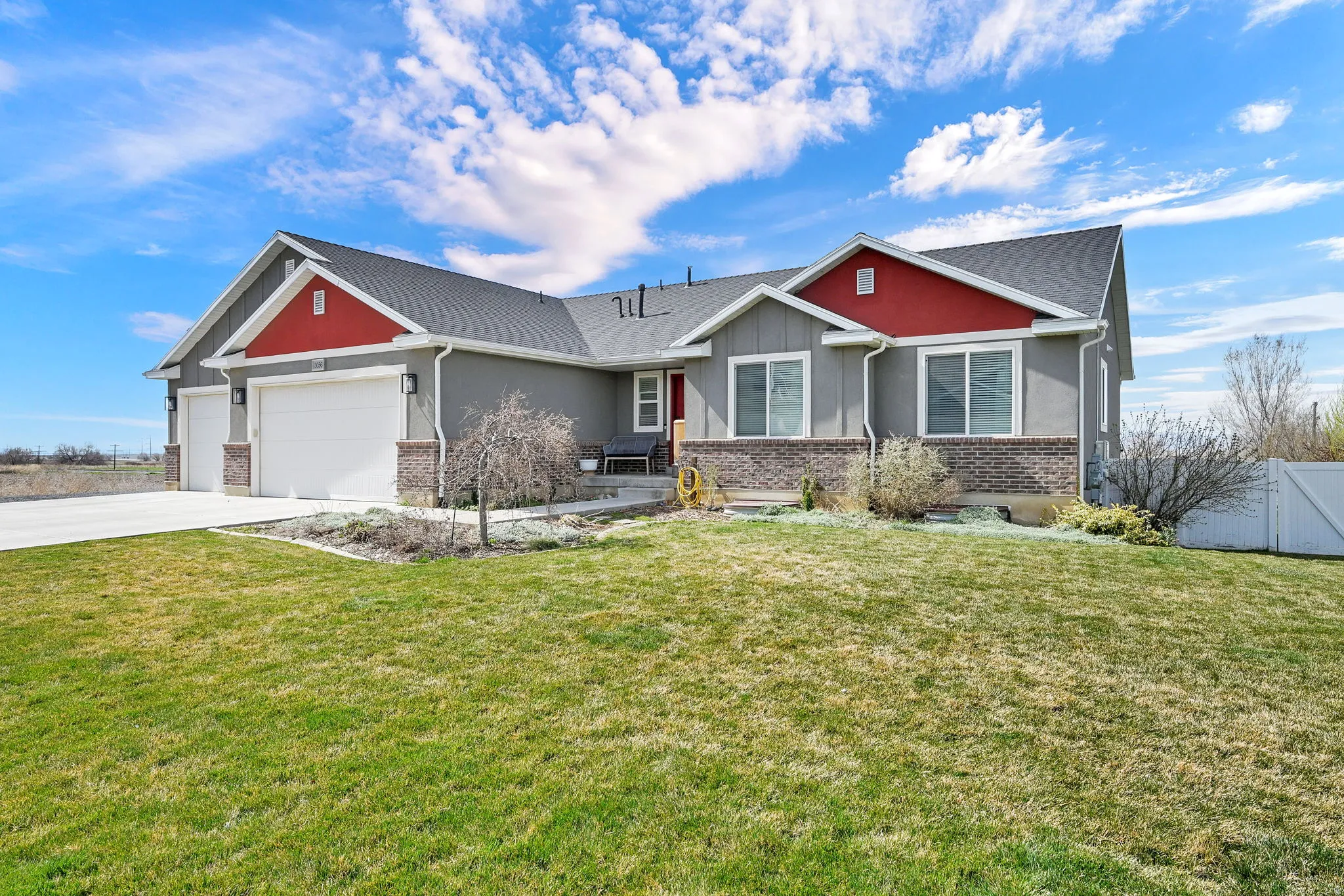 Craftsman inspired home with a garage, driveway, brick siding, stucco siding, and board and batten siding