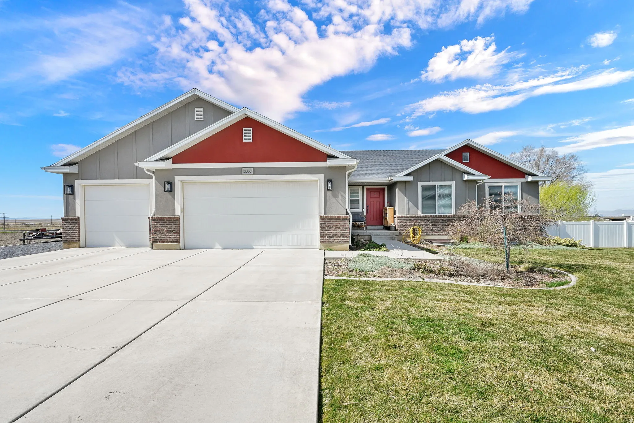 Craftsman inspired home featuring a garage, brick siding, driveway, and board and batten siding
