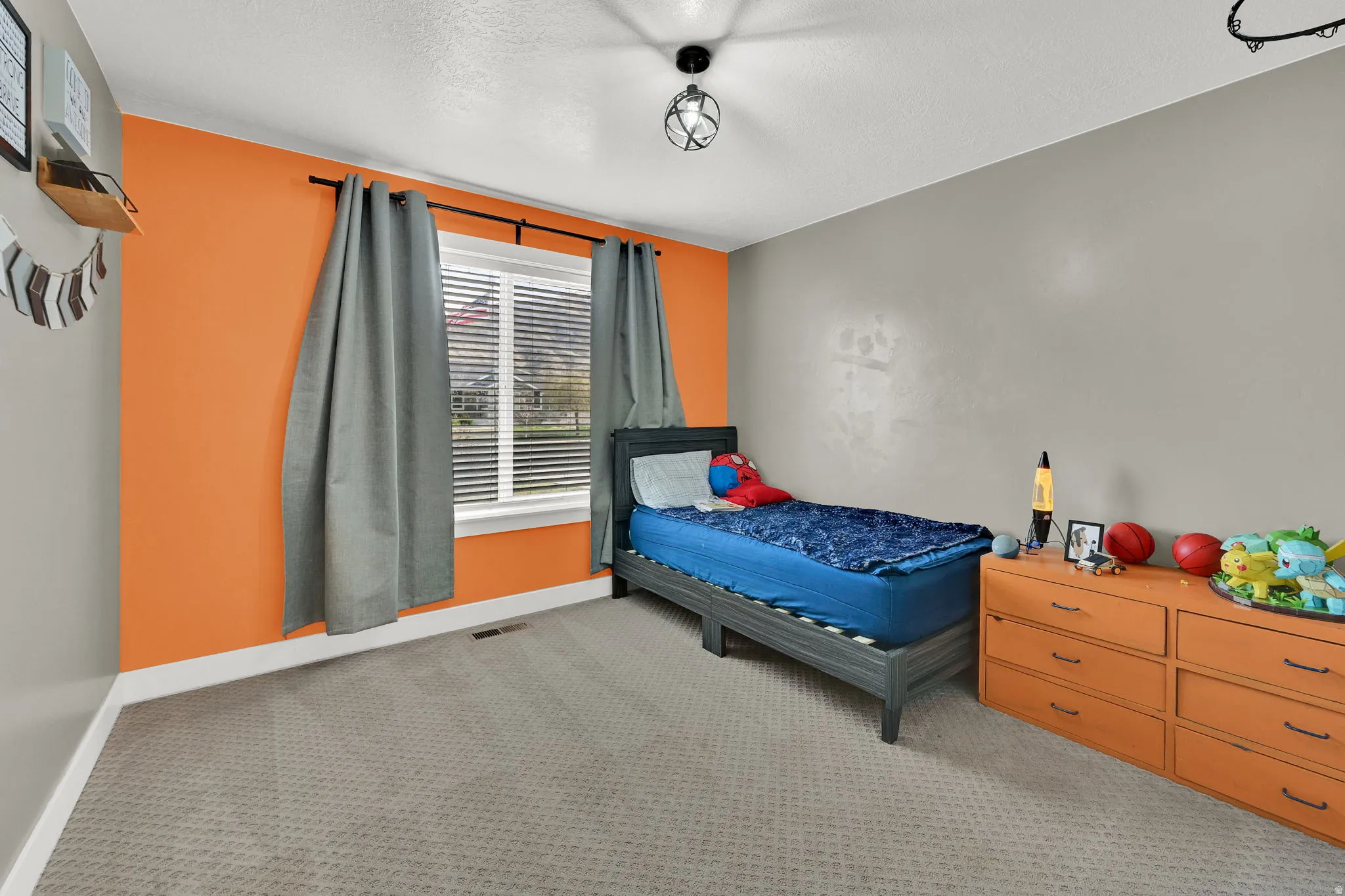 Bedroom featuring light colored carpet and a textured ceiling