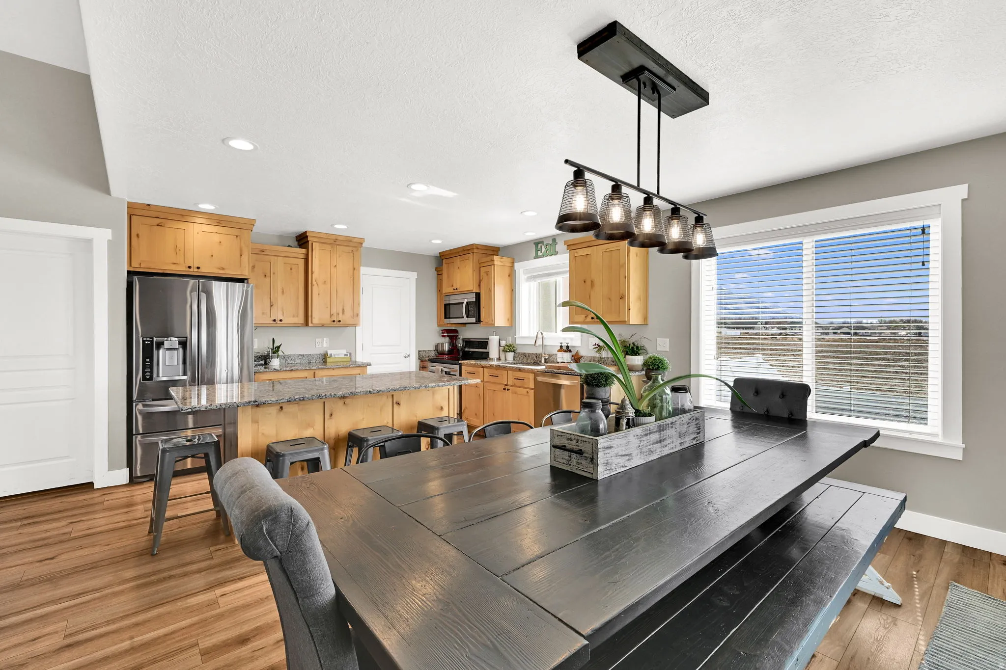 Dining area featuring recessed lighting, light wood-style flooring, and a textured ceiling