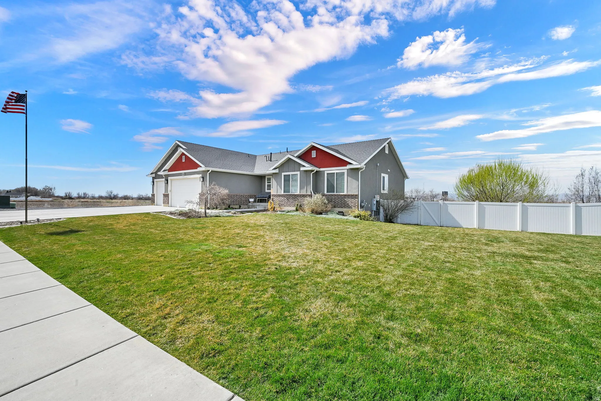 Craftsman house featuring an attached garage, driveway, and stucco siding
