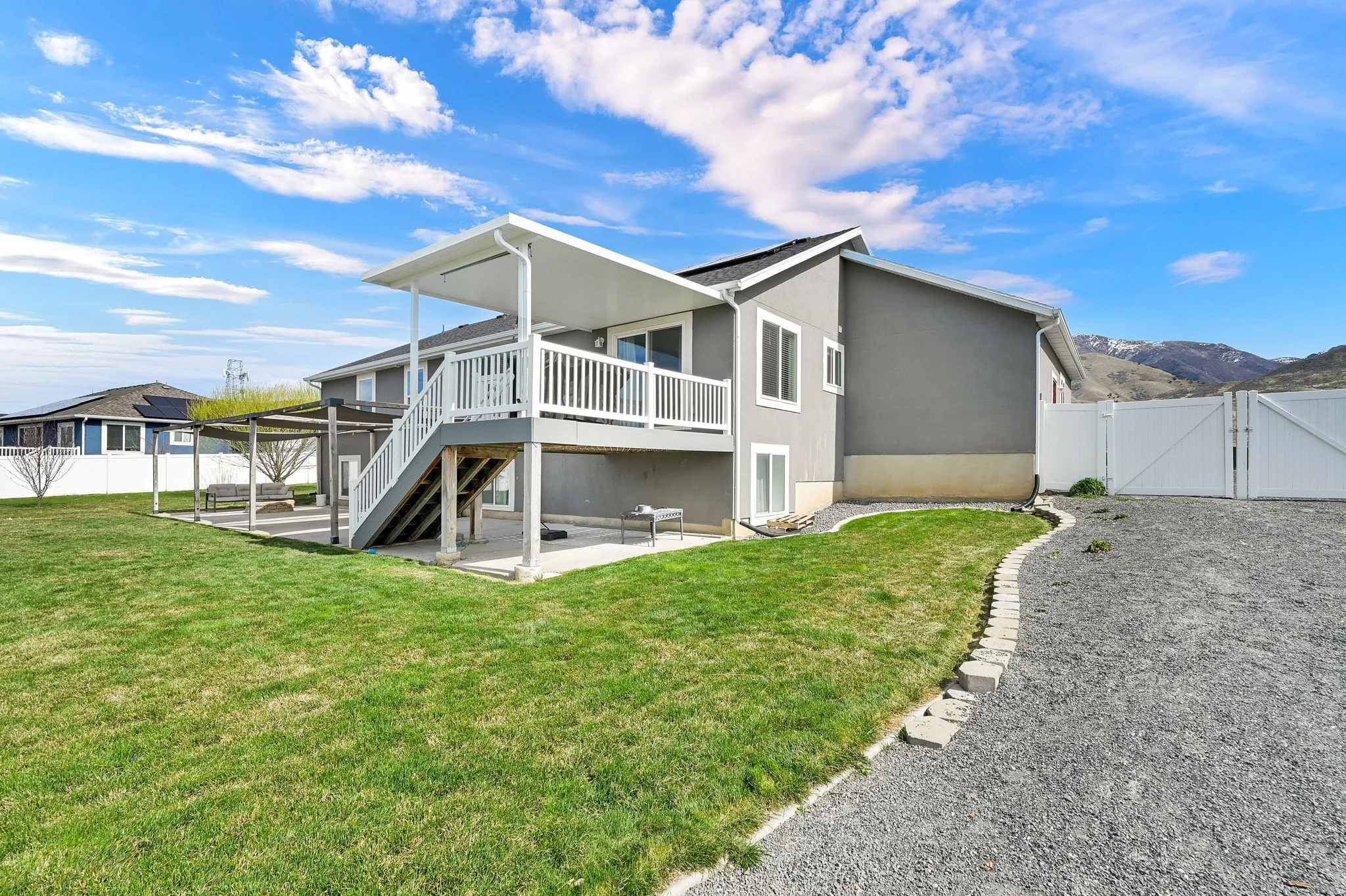 Back of property with a patio, a gate, a fenced backyard, a deck with mountain view, and stucco siding