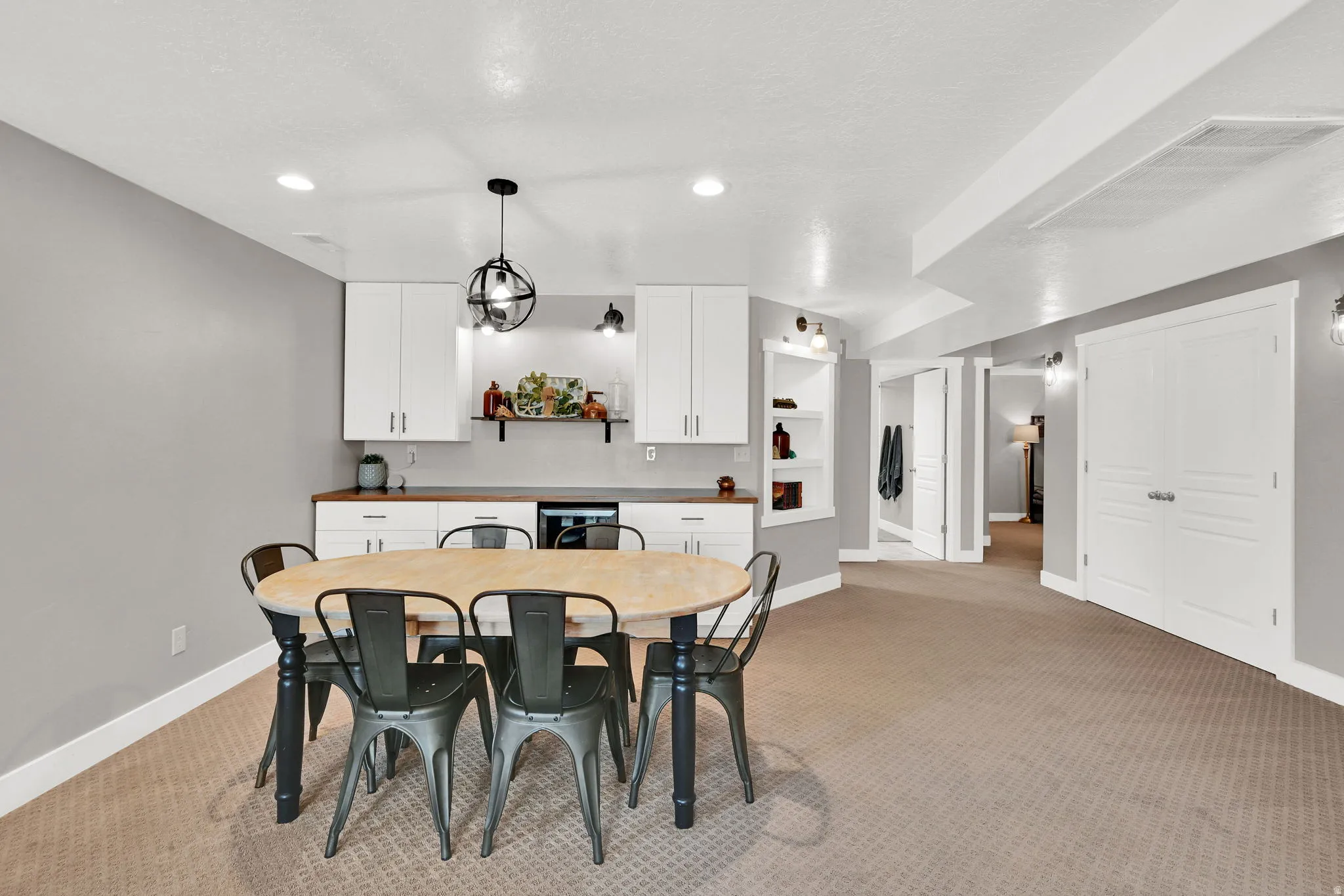 Dining room with light carpet and recessed lighting