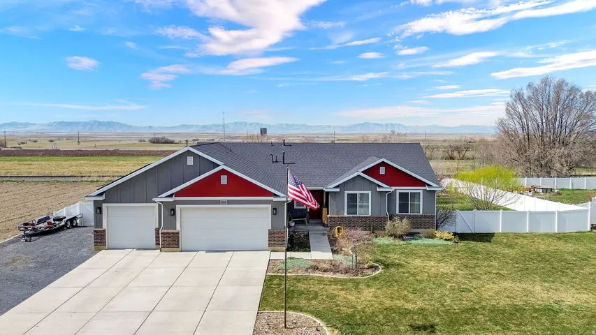 Craftsman-style home featuring brick siding, a garage, driveway, board and batten siding, and a view of countryside