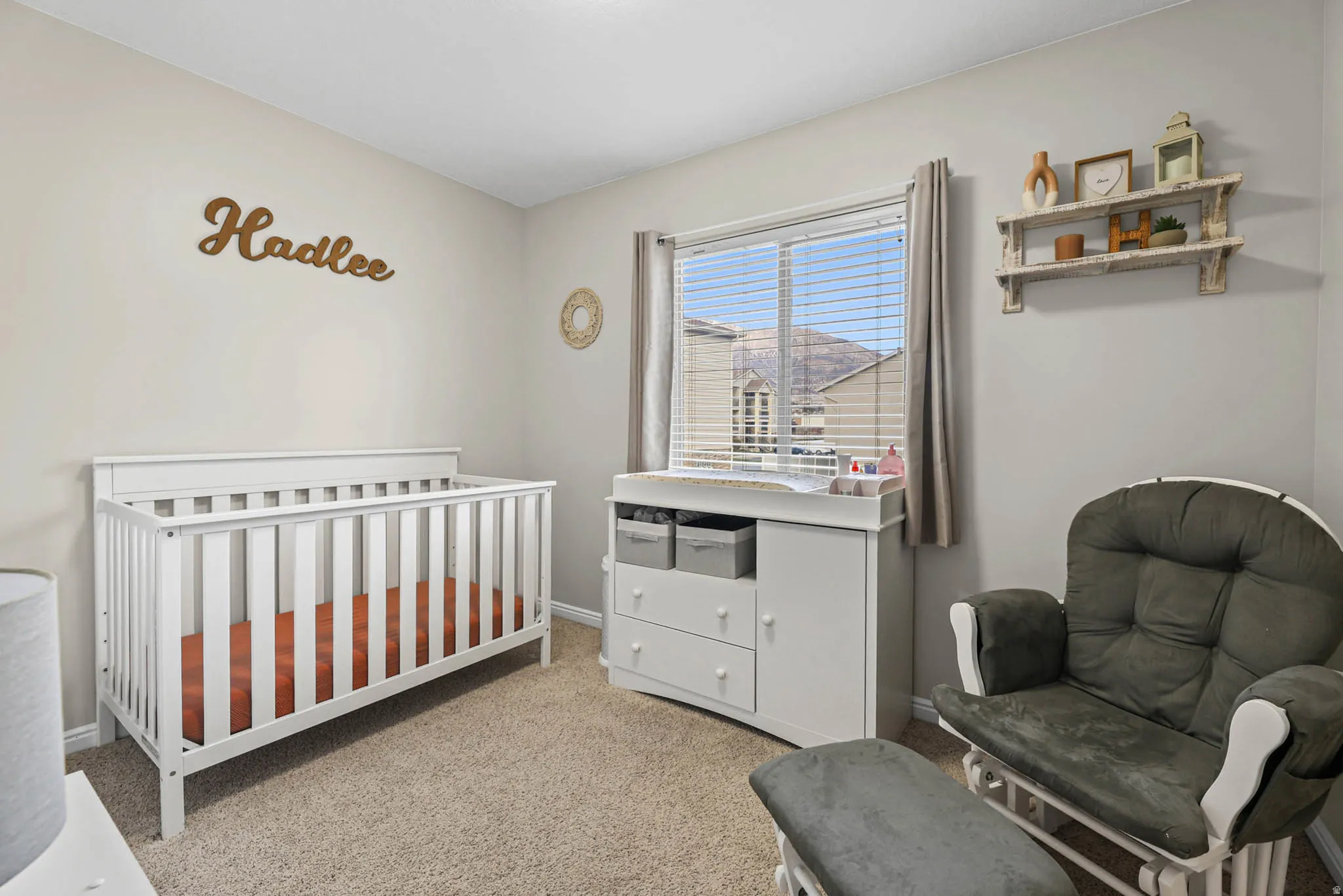 Bedroom with a crib and light carpet