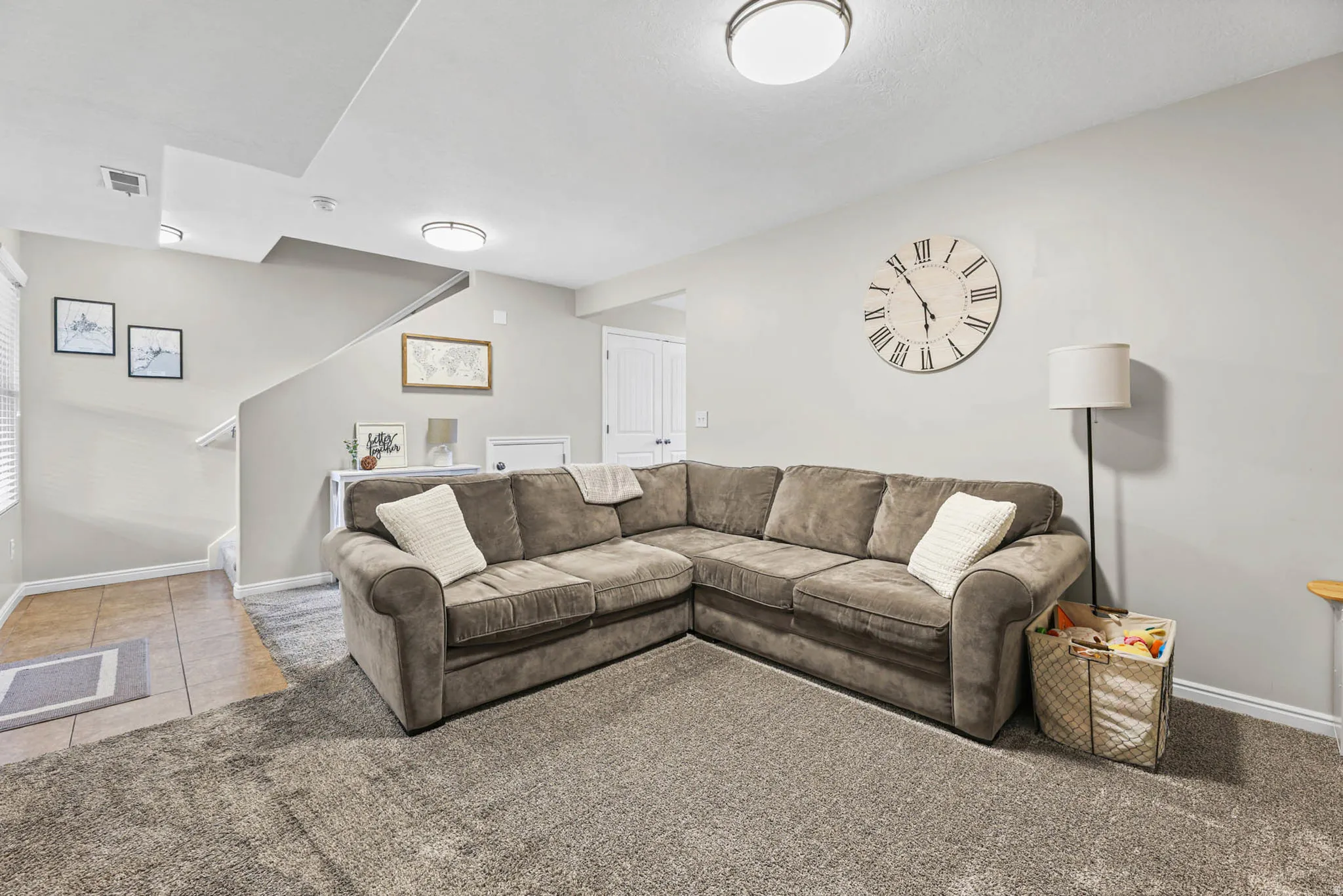 Living area with light tile patterned floors and light colored carpet