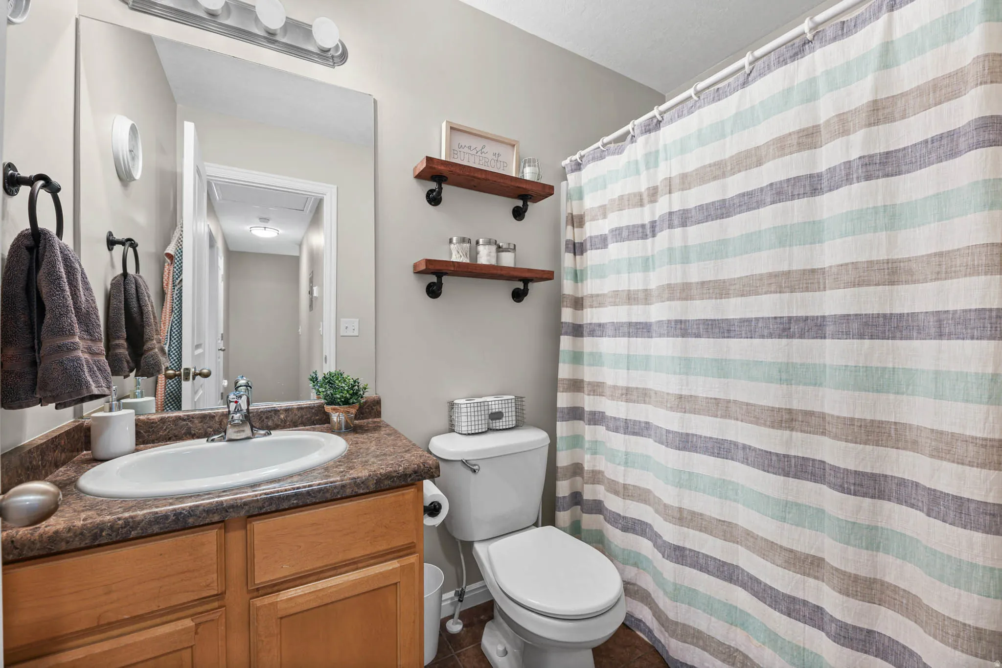 Bathroom with vanity, a shower with curtain, and dark tile patterned floors