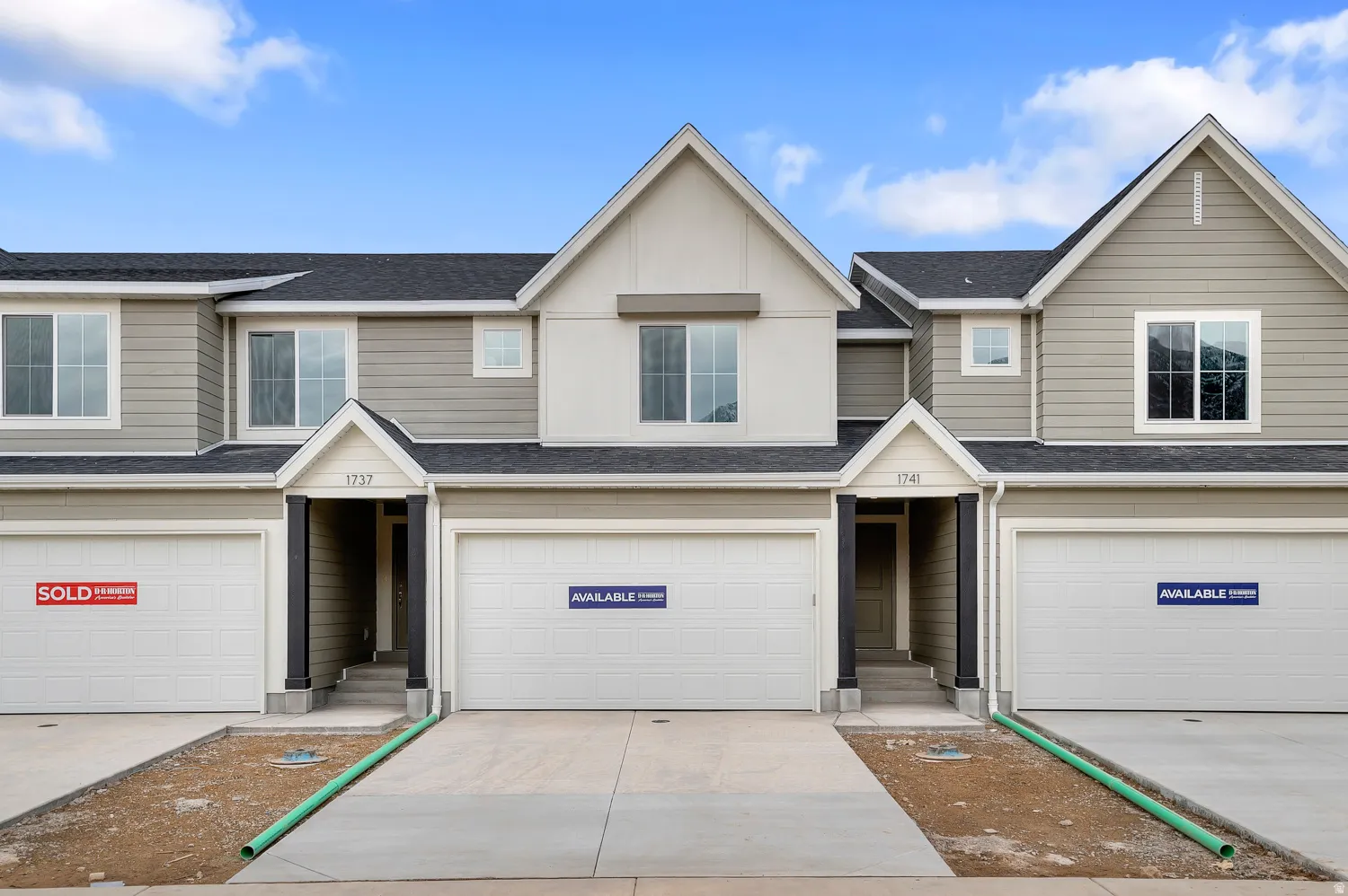 Traditional home featuring roof with shingles, a garage, and concrete driveway