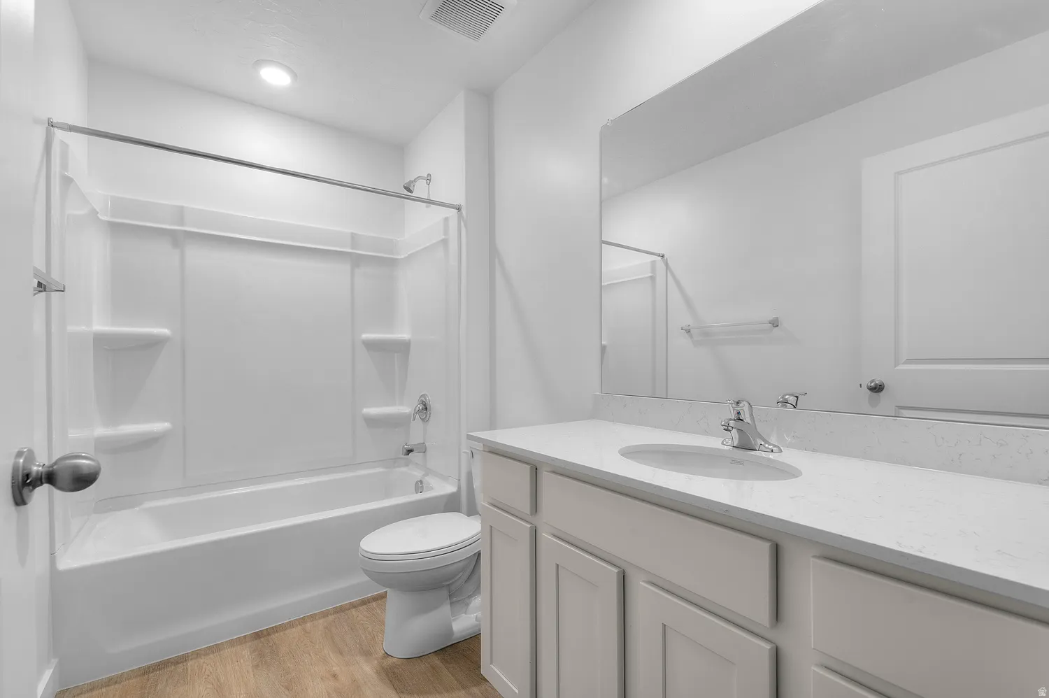 Bathroom featuring vanity, light wood-style flooring, and shower / washtub combination