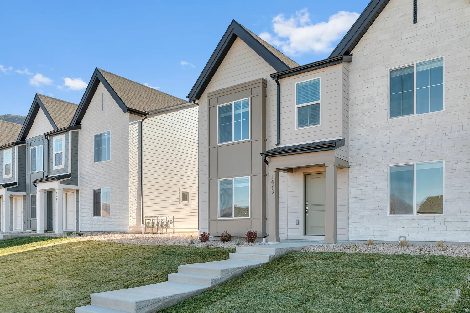 View of front of property with a front yard and stone siding