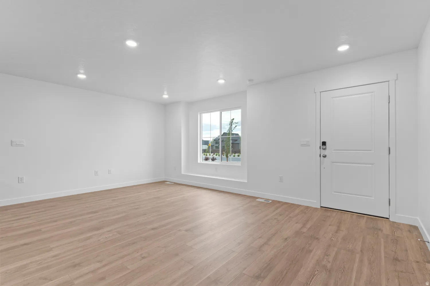 Entryway with light wood-style floors and recessed lighting
