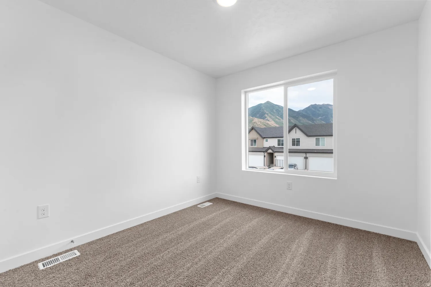 Empty room featuring baseboards and carpet flooring