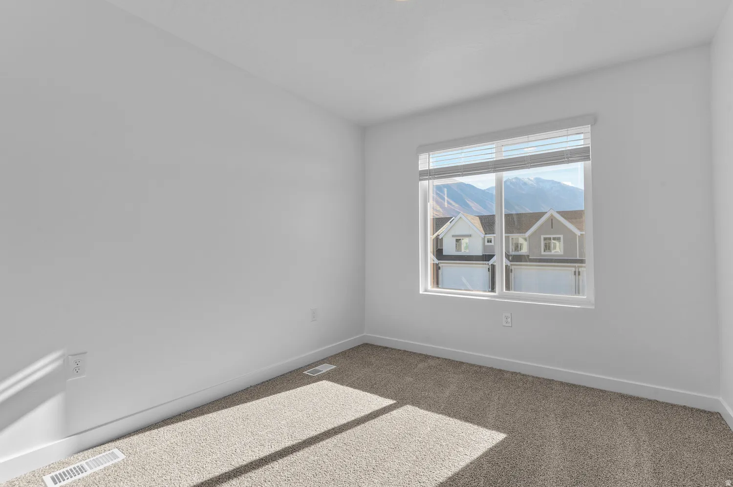 Spare room with carpet flooring and a mountain view