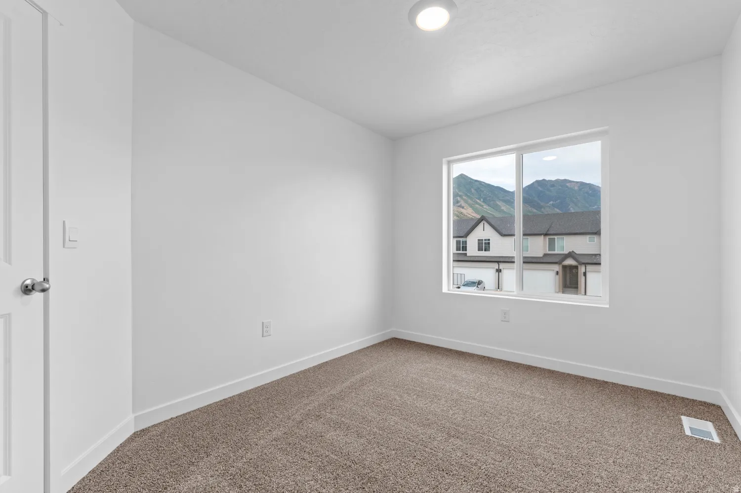 Carpeted spare room with baseboards and a mountain view