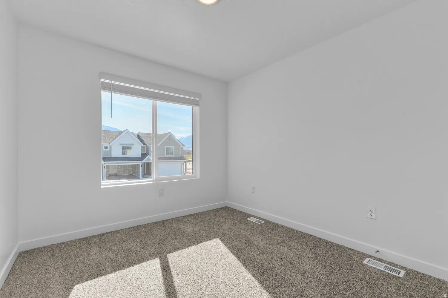 Unfurnished room featuring baseboards and dark colored carpet