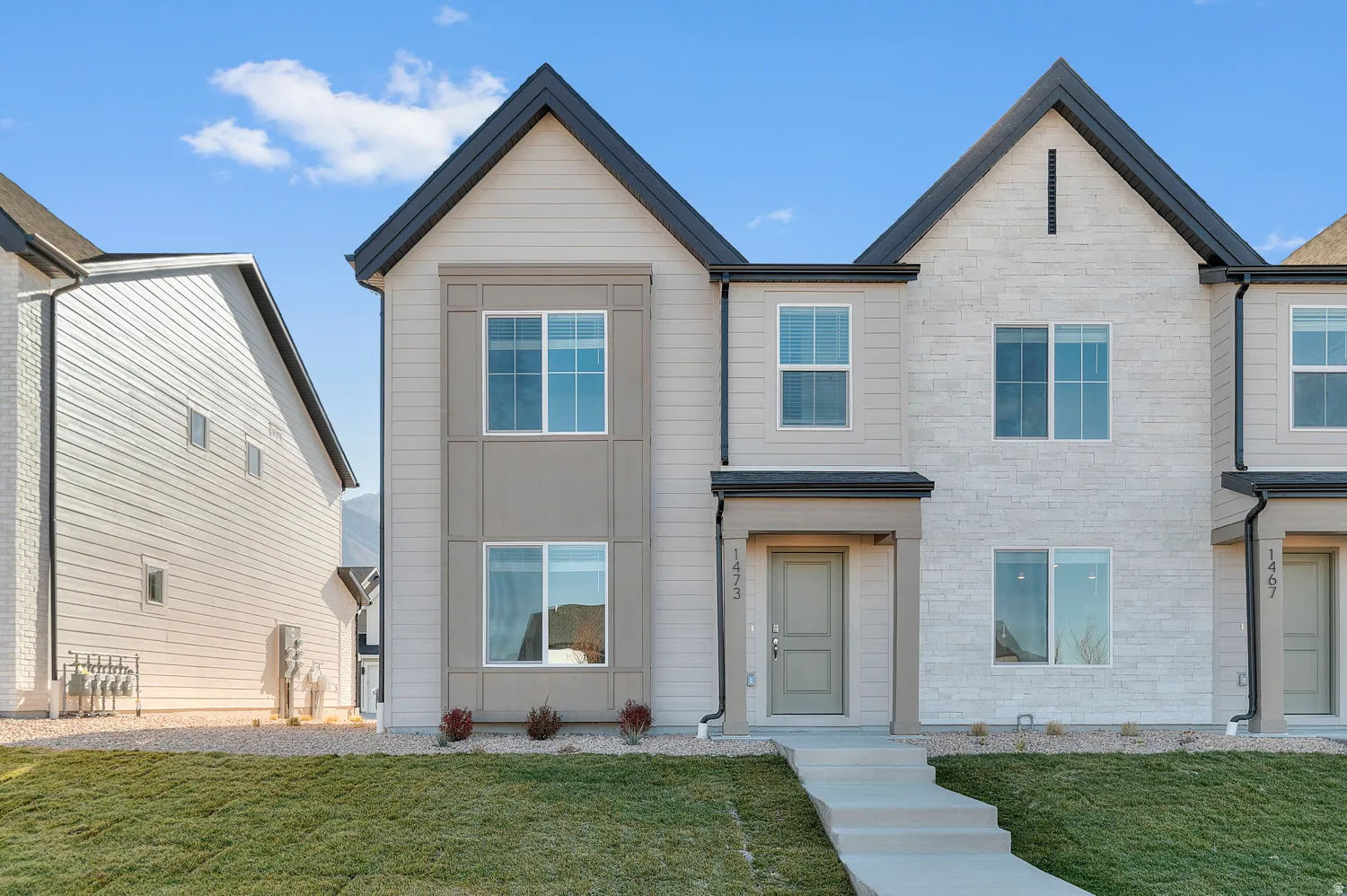 View of front of property featuring stone siding and a front yard