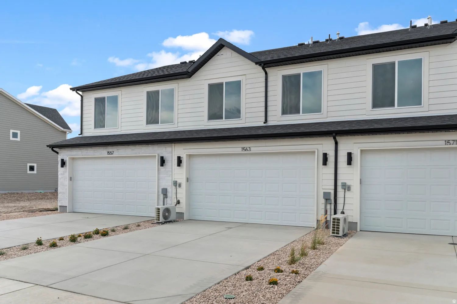View of front of house with a garage, roof with shingles, and concrete driveway