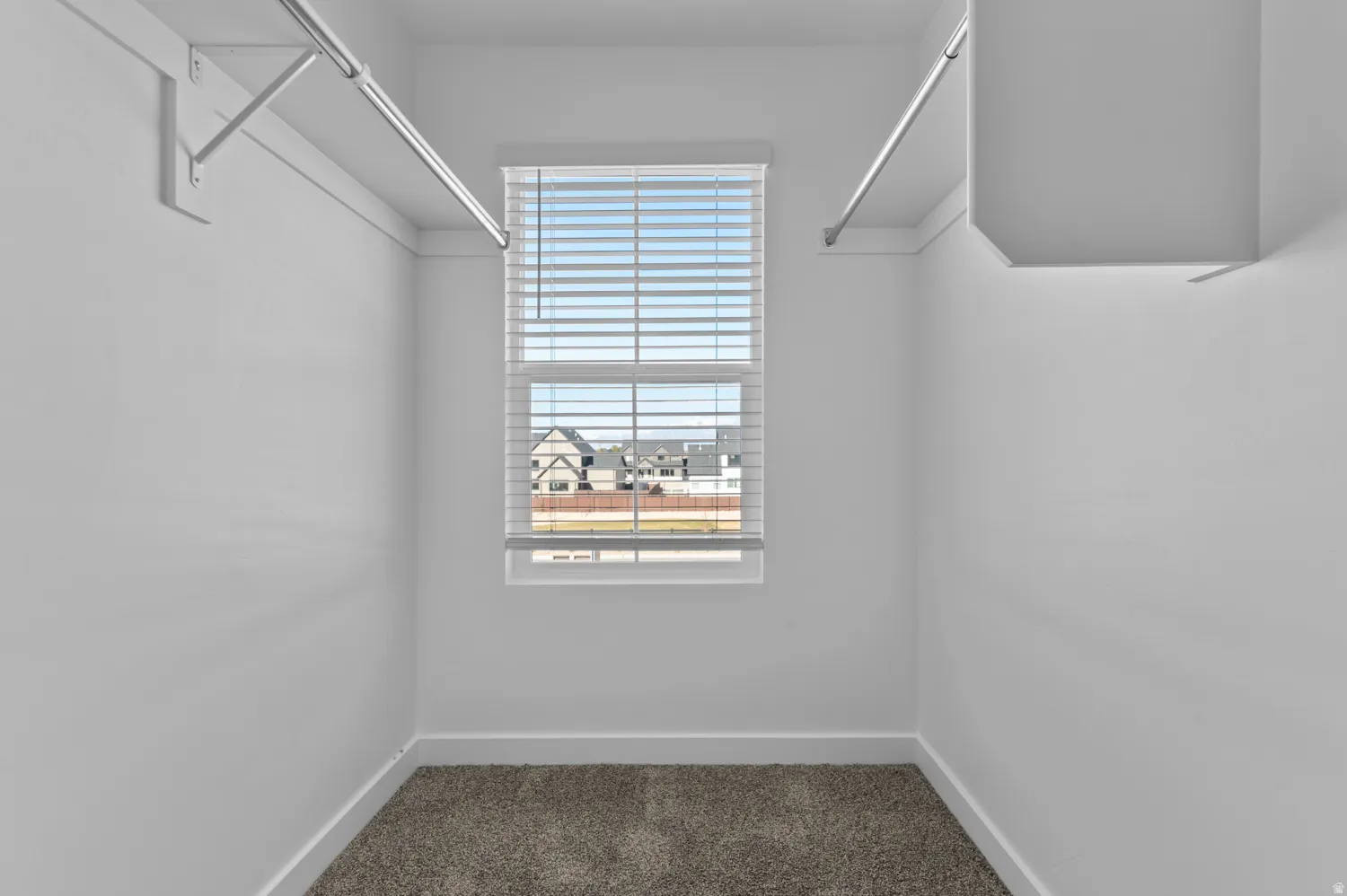 Walk in closet with dark carpet