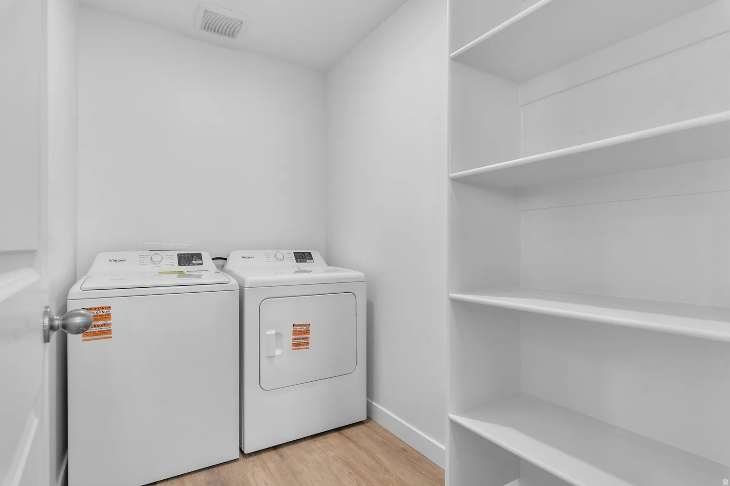 Laundry room featuring light wood-style floors and washer and clothes dryer