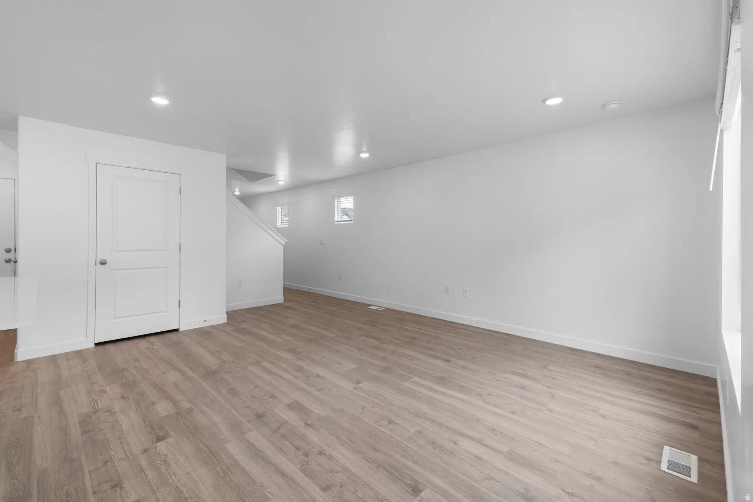 Below grade area featuring light wood-type flooring and recessed lighting