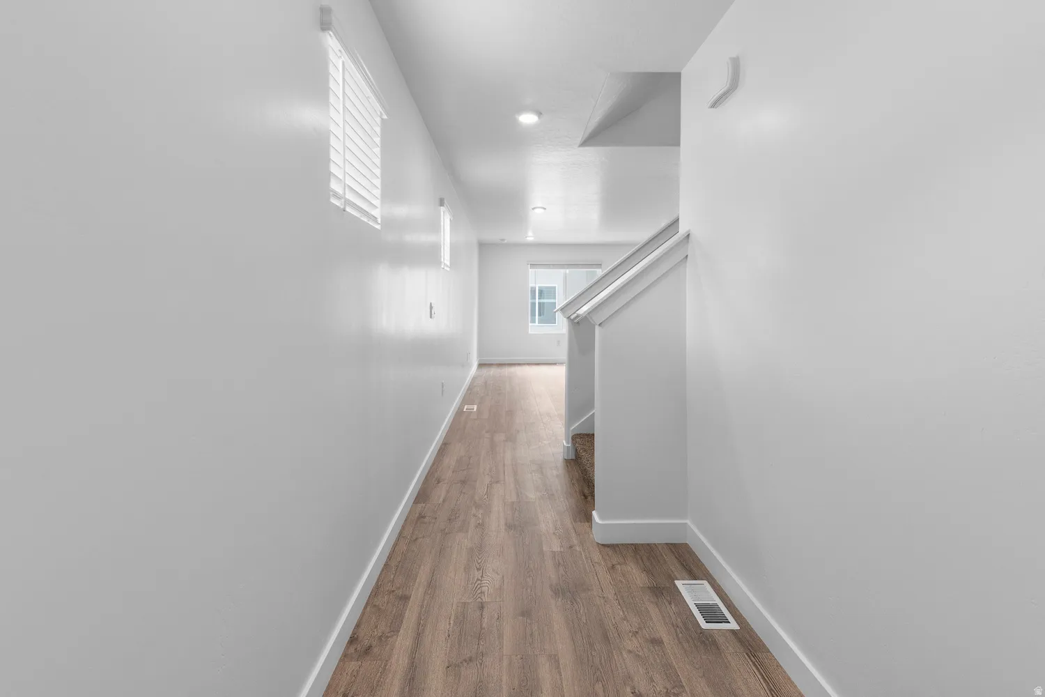 Hallway featuring baseboards and dark wood finished floors