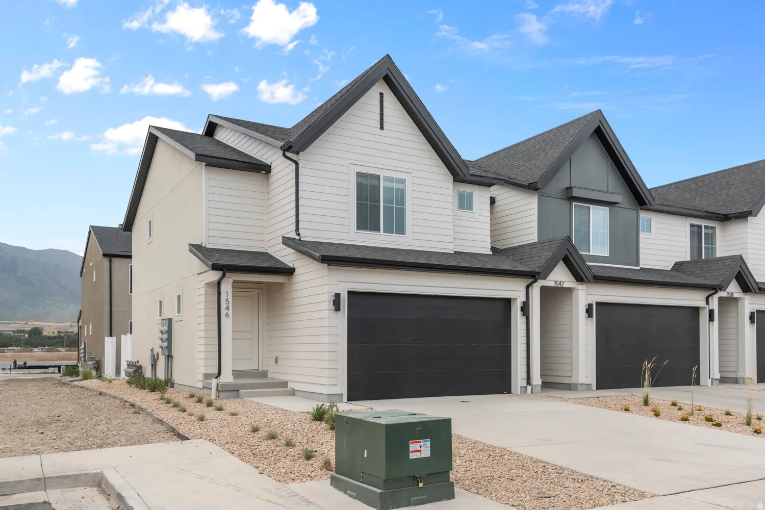 View of front of property featuring roof with shingles, an attached garage, driveway, and a mountain view