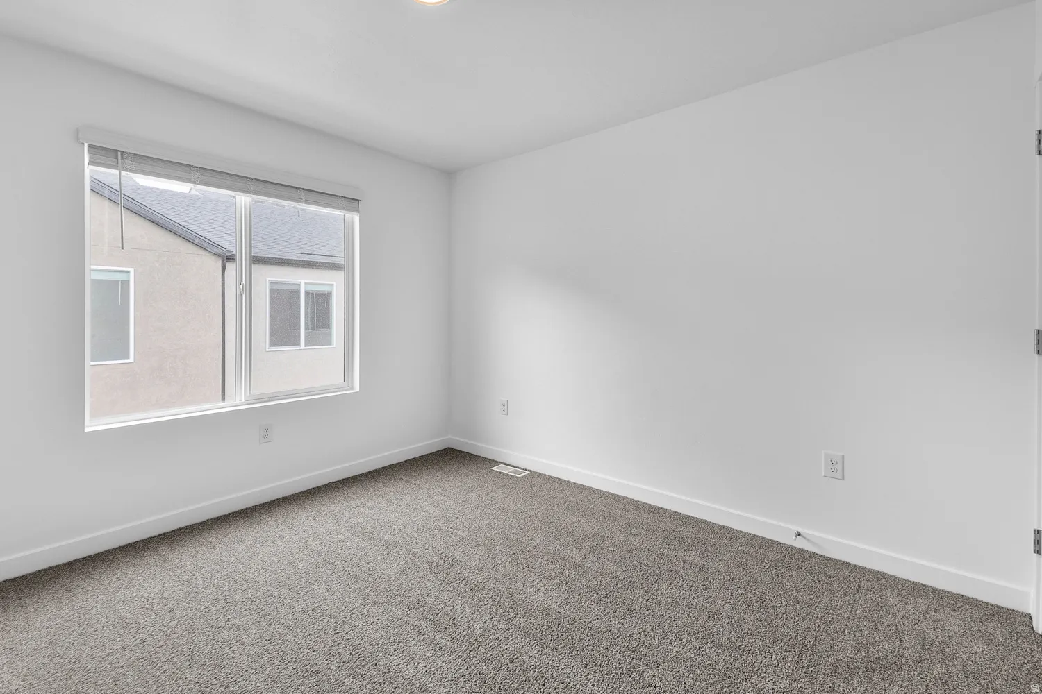 Carpeted empty room featuring baseboards