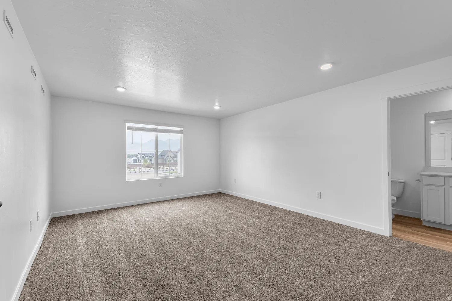 Spare room with light colored carpet, recessed lighting, and a textured ceiling