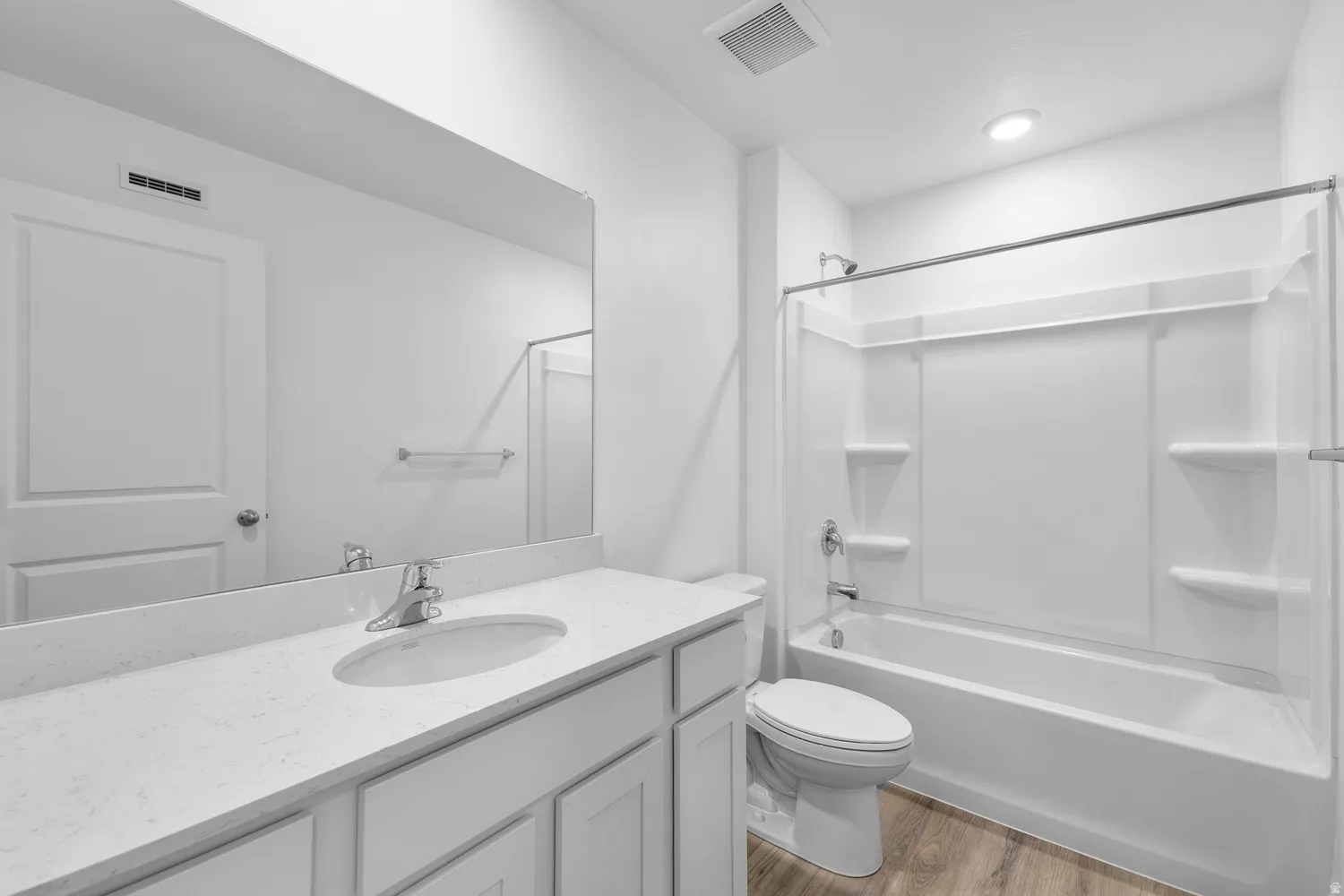 Bathroom featuring light wood-style flooring, vanity, and washtub / shower combination