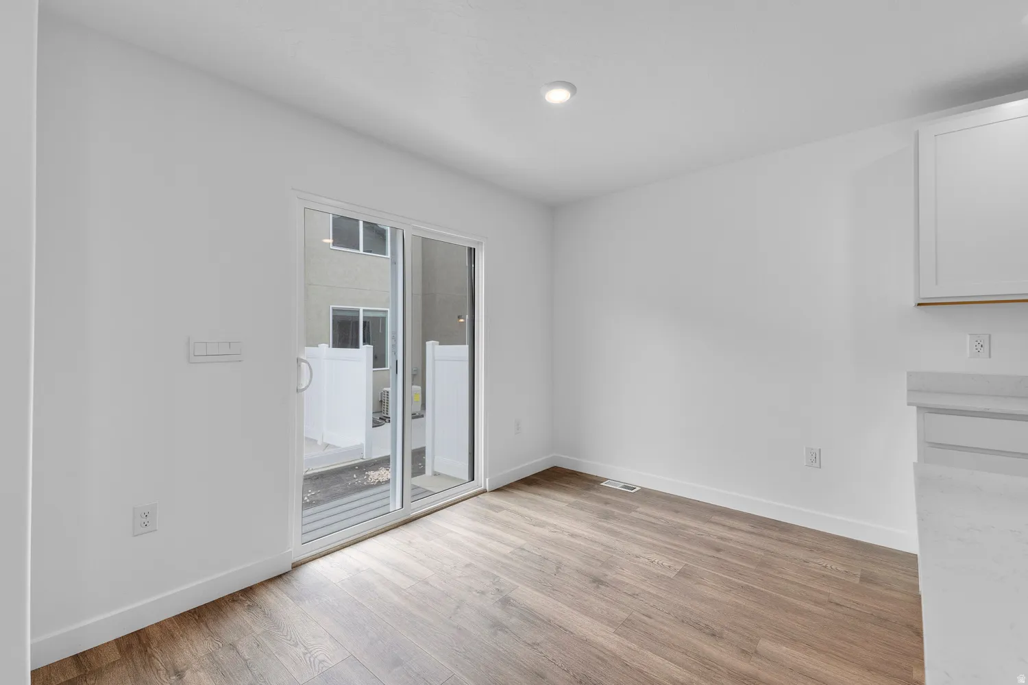 Unfurnished dining area with baseboards and light wood-style flooring