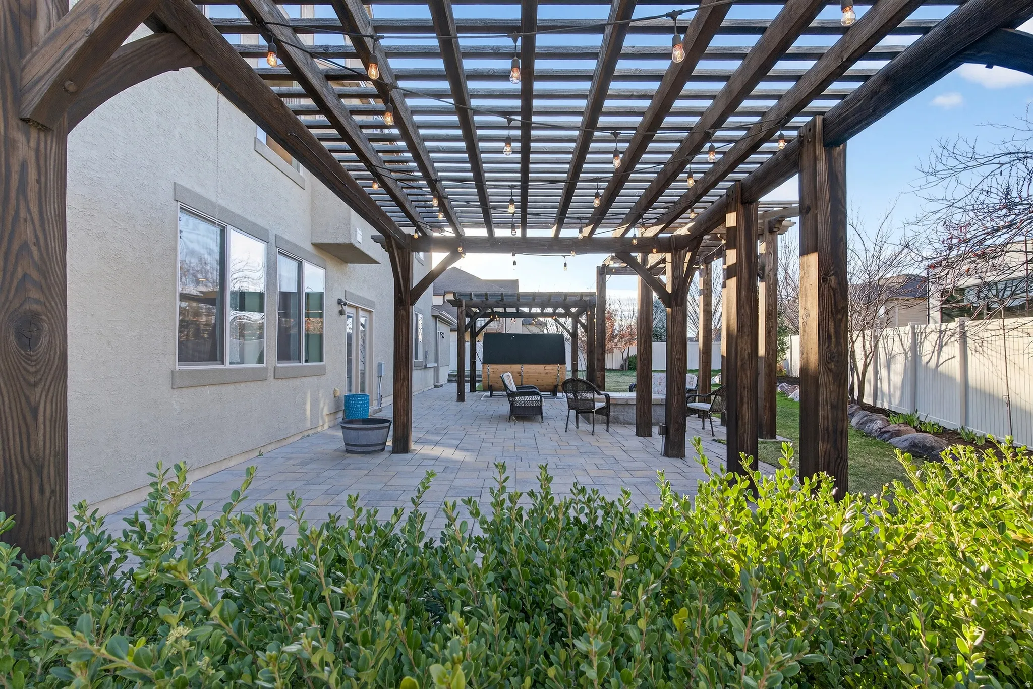 Fenced backyard with a pergola, a patio area, and an outdoor fire pit