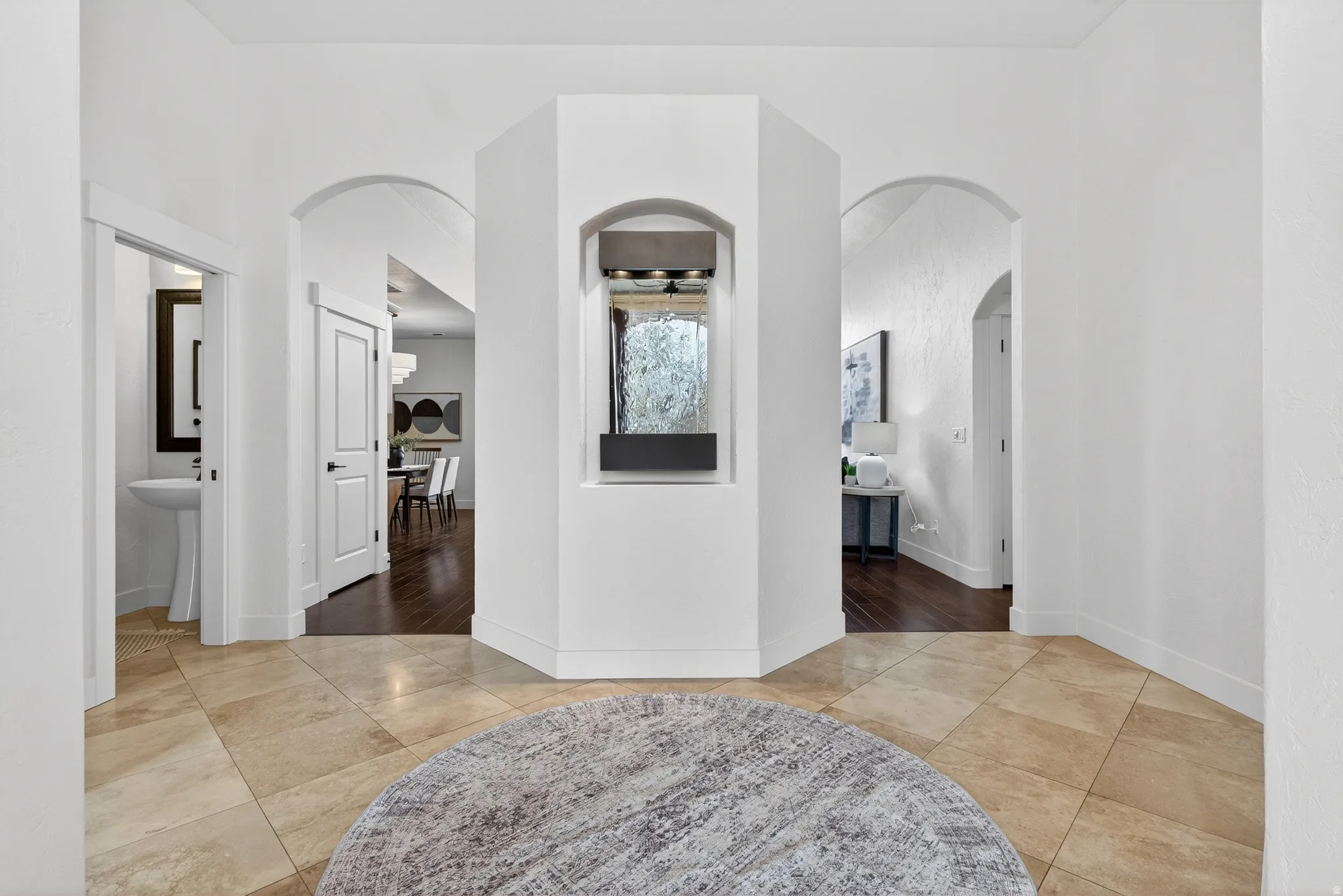 Corridor featuring light tile patterned floors and arched walkways
