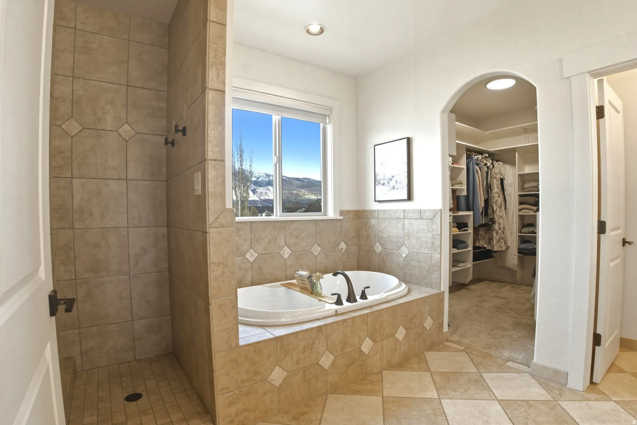 Bathroom with a bath, a shower stall, a spacious closet, light tile patterned flooring, and recessed lighting